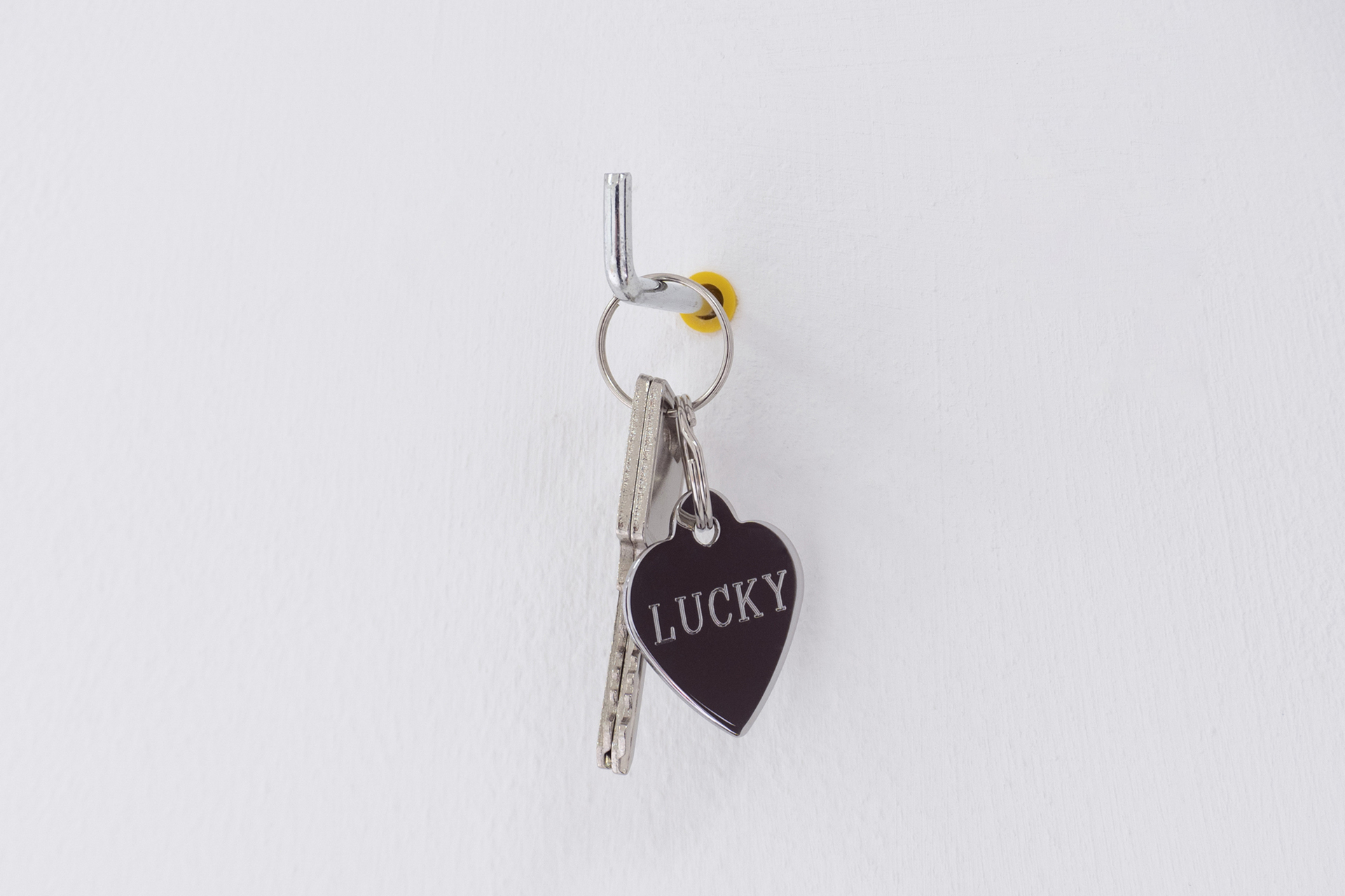 Wisrah Villefort, Lucky, 2020 (keys to lockable display, engraved keychain, wall plug)