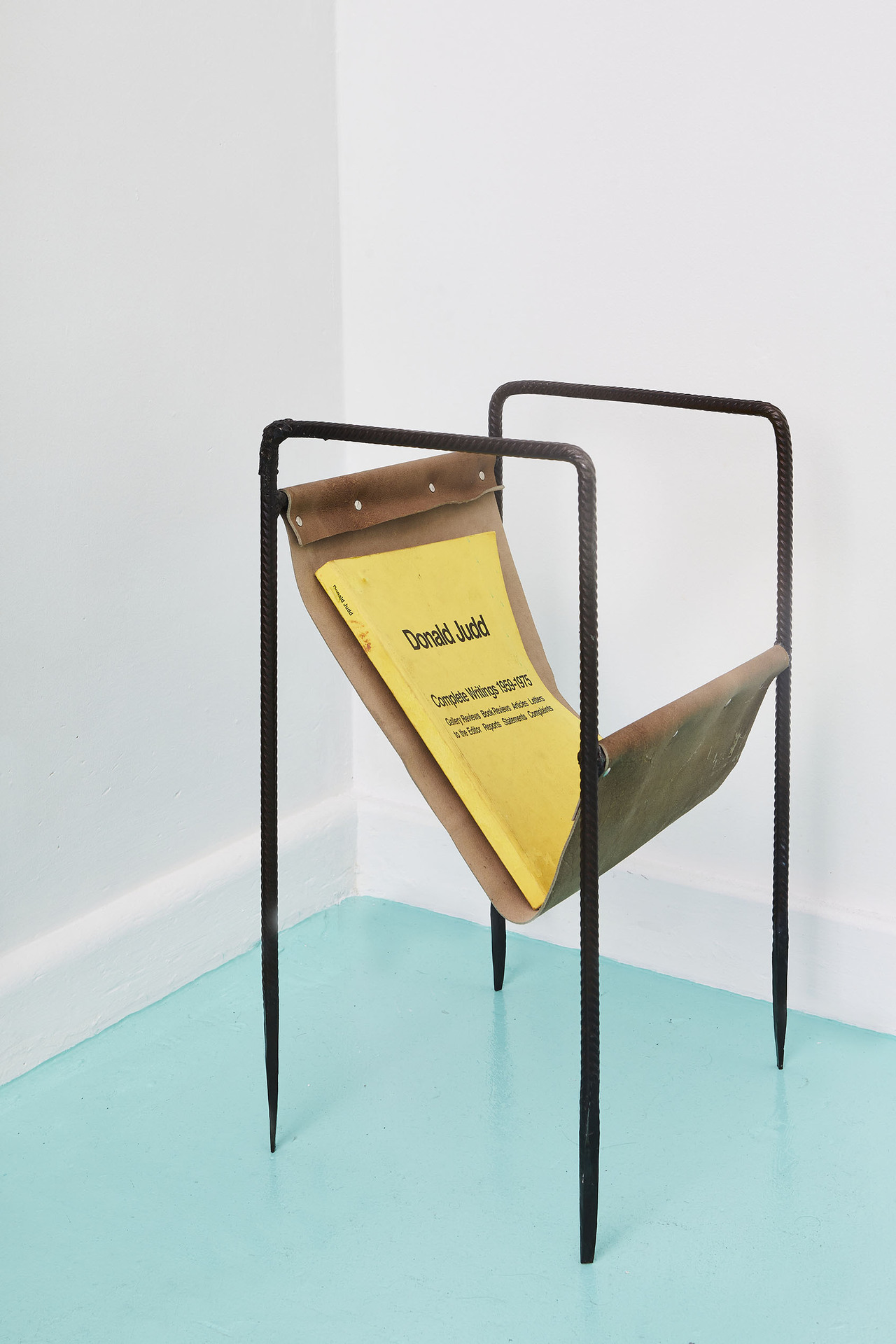 Jah Maskell Magazine stand #1, 2019 Welded steel, cow hide, metal buttons, published writings of Donald Judd