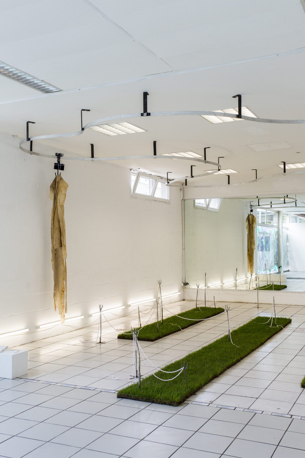 Merle Dammhayn, »Ein Gespenst geht um«, 2020, installation with electronic sculpture & ceramic elements & shed snake skin & lay turf & bead chains & soundscape & light tubes & fog & a book, approx. 5x7 meters