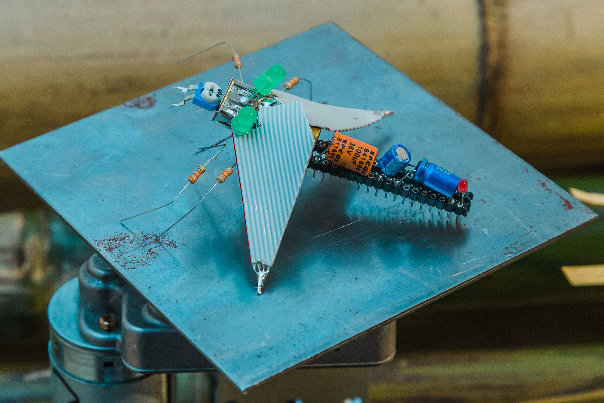 Monika Czyżyk in collaboration with Gregoire Rousseau, Geographies of a lonely Pole  (Cluster - Micro dragonflies), 2020, capacitors, USB connectors, trimmer, max 232 chip, metal plate, socket rails with flat cables, 12VDC motor, slowed down with power supply, detail