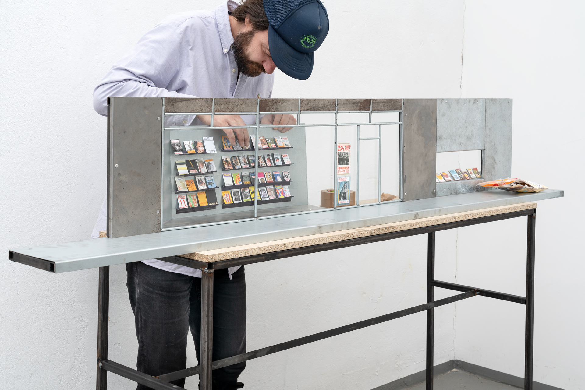 Wilhelm Klotzek, "Kunstbuchhandlung", 2020, Partially galvanized sheet steel, lacquer on glass, paper, 210 x 40,5 x 142,5 cm