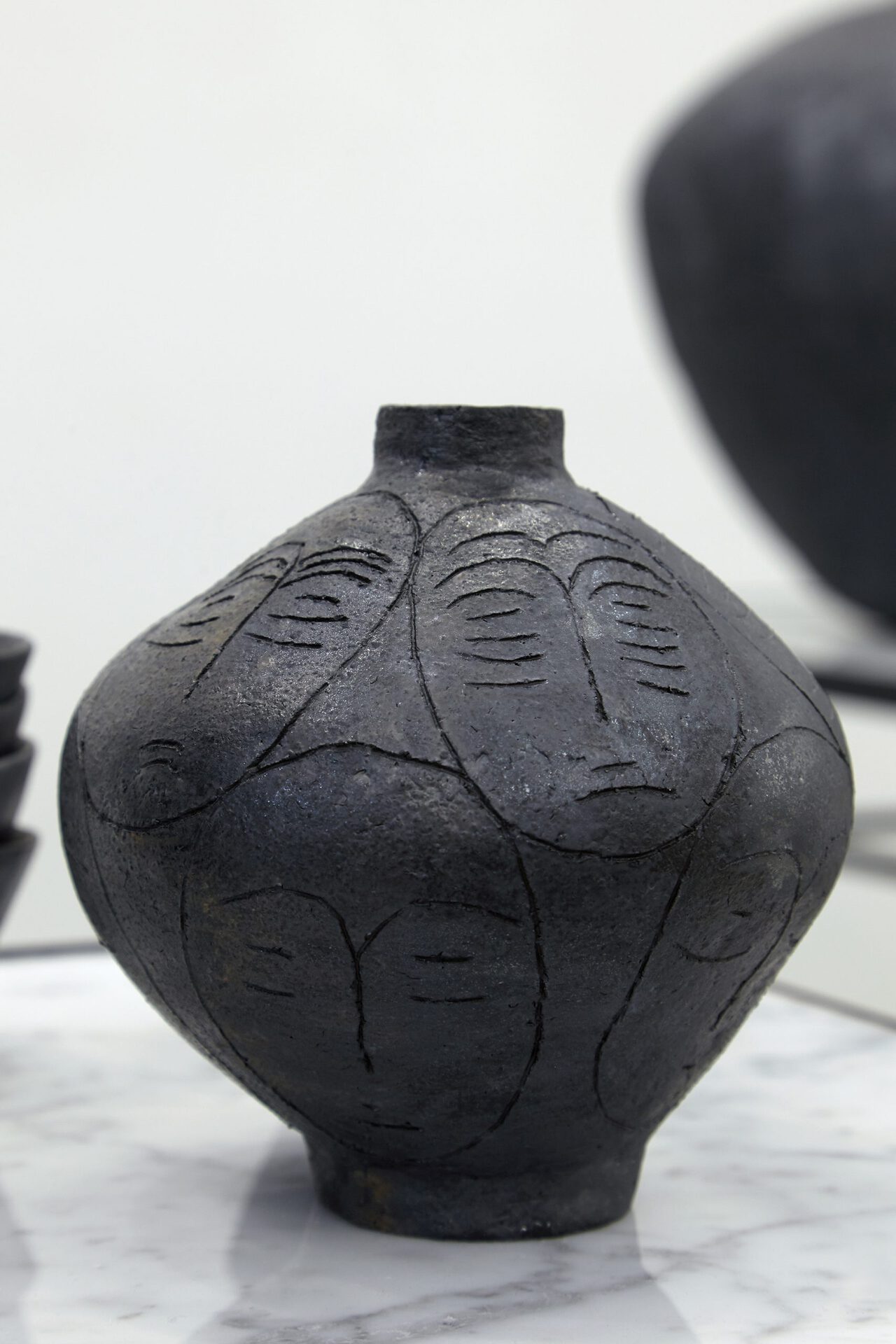 Sári Ember: Small black vase with heads, 2020, ceramics, 17x15x15 cm, Photo: Sári Ember, courtesy of Ani Molnár Gallery