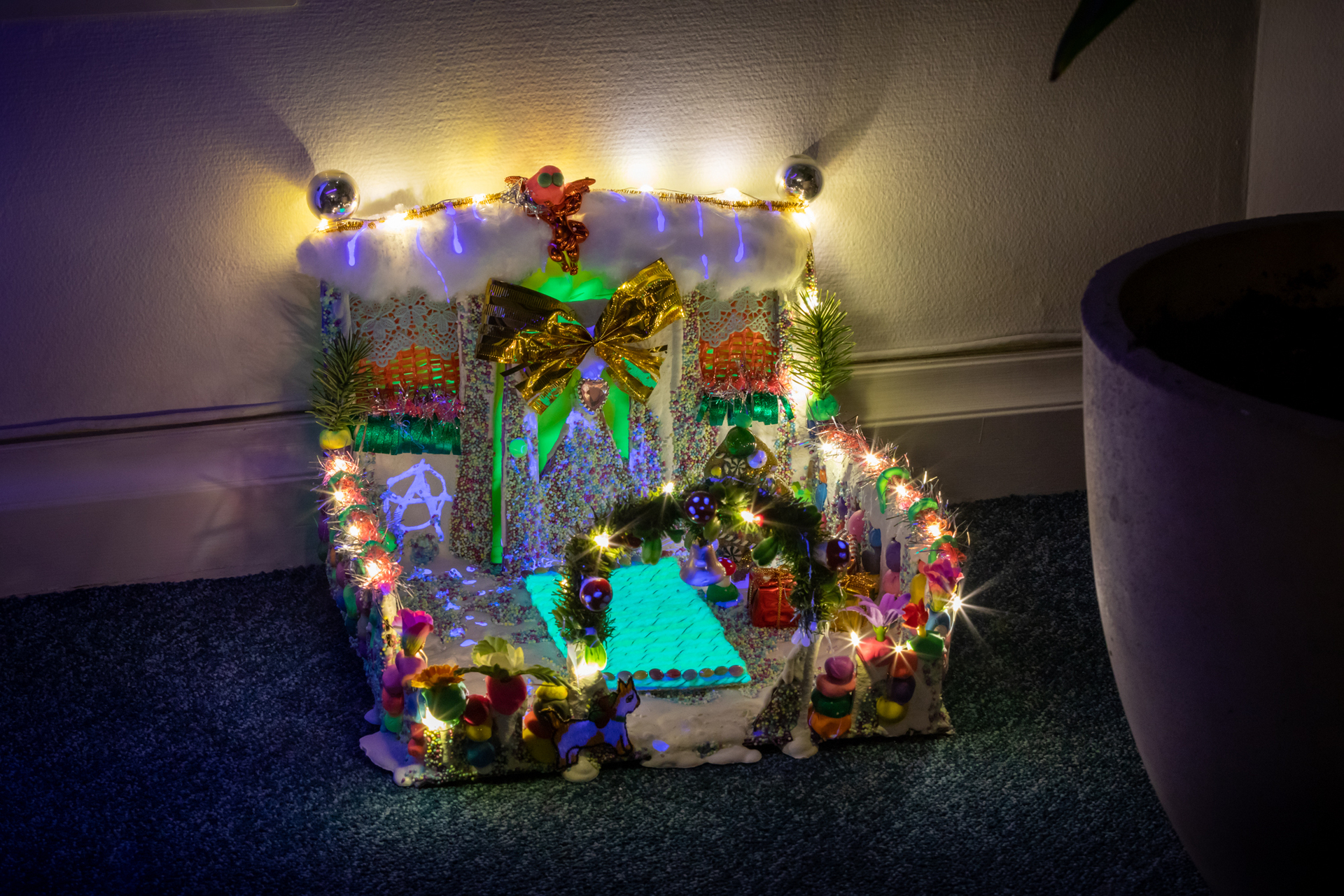 Jonna Karanka, Satoi tai paistoi, bileystäväni 100%, 2020, plaster, cardboard, led lights, modeling clay, uv-paint, plastic flowers, tinsels, acrylic yarn, sprinkles, 26x28x23cm