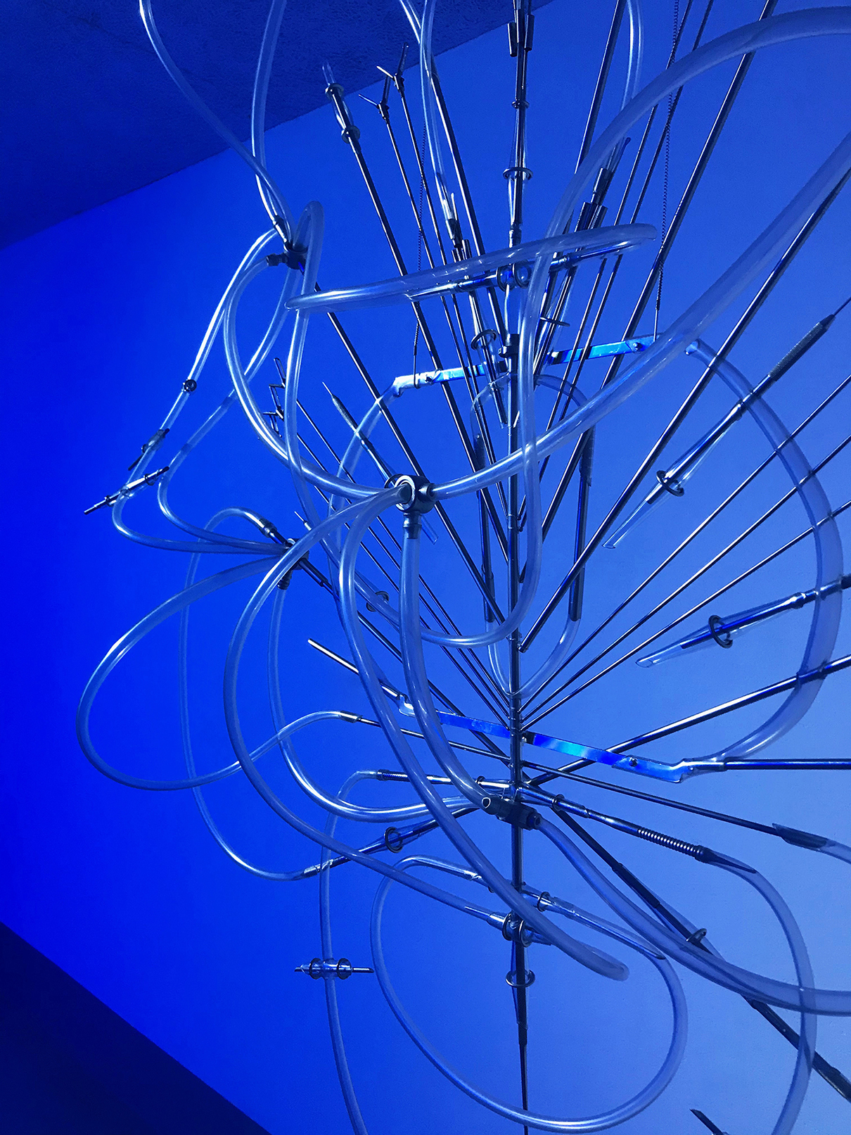 Floryan Varennes, Iris, 2020 Medical tubes, medical instruments, blue light; 100 x 130 cm
