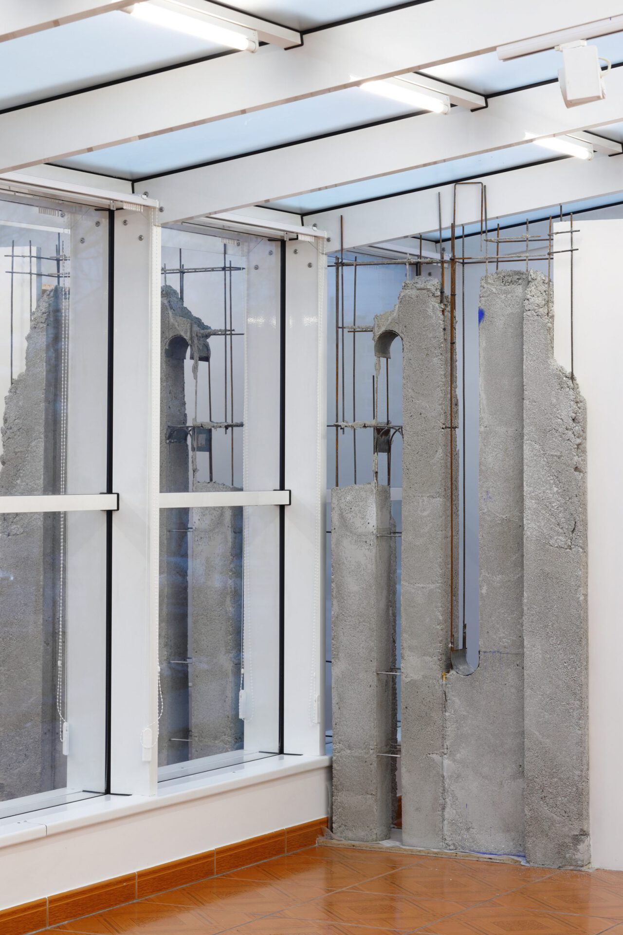 Evita Vasiļjeva,  “Untitled V”, steel rebars, concrete, blue pigment, wood, gutter, plastic, double-sided tape, wall, window, floor,  light, 2020