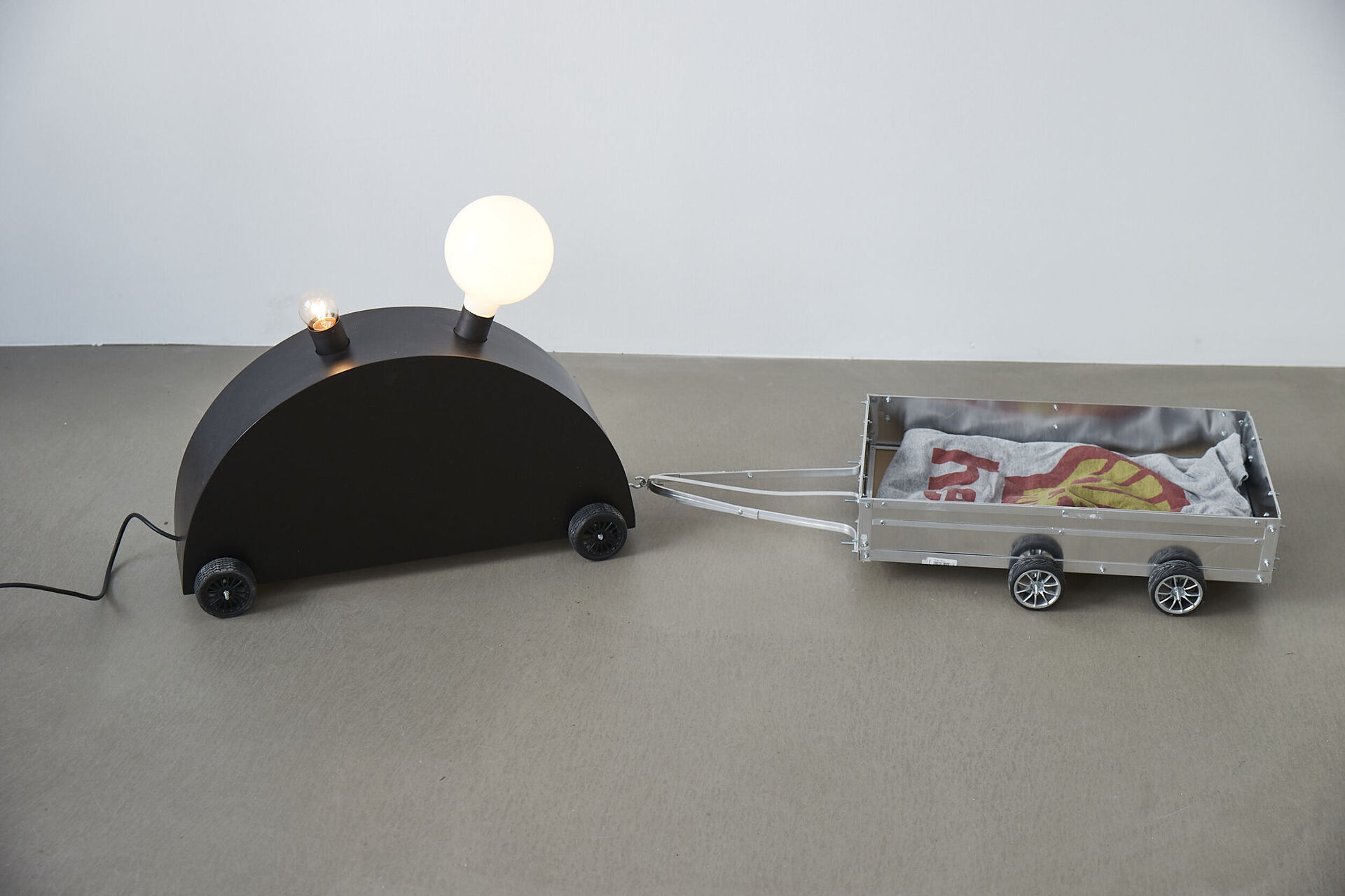 Frieder Haller, Memphis Blues (after Martine Bedin) VI, 2021 Wood, wire, board, electrical wiring, two light bulbs and model car wheels 45 × 127,5 × 34 cm / 17.7 × 50.1 × 13.3 inches