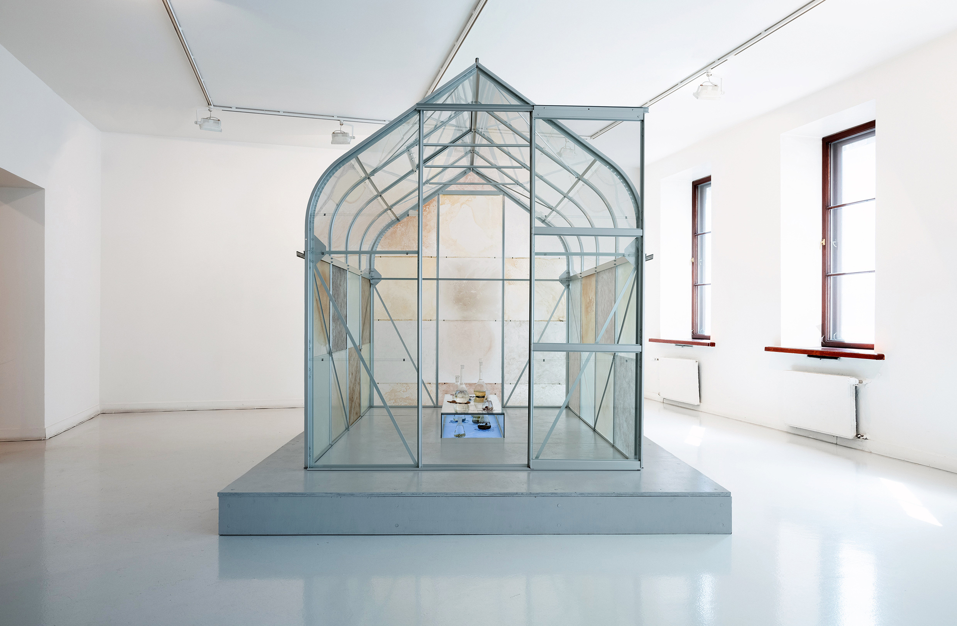 Elsa Salonen, Veden väelle, 2019, natural elements collected from the Finnish Baltic Sea and its shores, colours distilled or ground from them, glasshouse, glass, silver, lights, 230x200x260 cm
