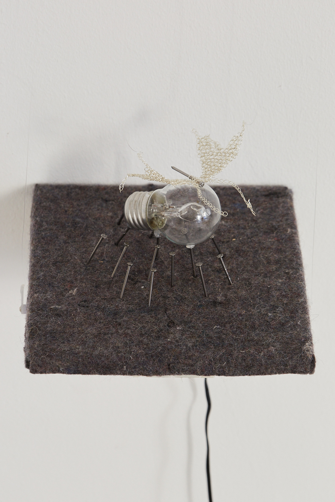 Julia Creuheras, 'El reloj marca una hora infinita', 2021, silver, felt on wooden board, nails, light bulb, chip and motor, 18 x 19 x 19 cm.