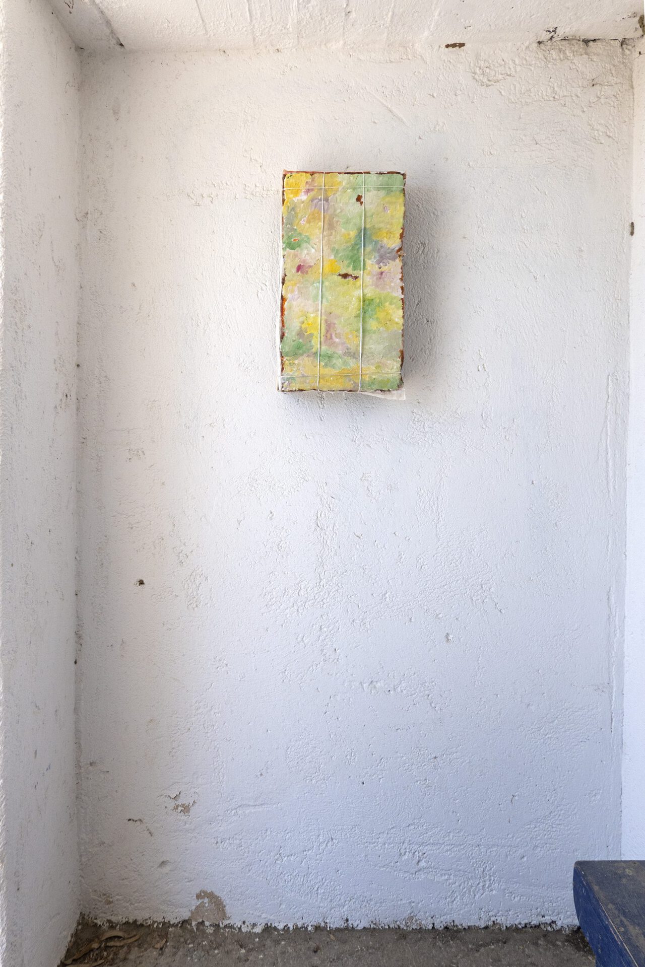 Ishai Shapira Kalter, "Aspro Chorio", 2021. Installation view. Oil painting on canvas, glued, stretched, and tied with nylon string to a vegetable / fruit wooden crate, signed with blue pen. 46 x 27 x 9.5 cm