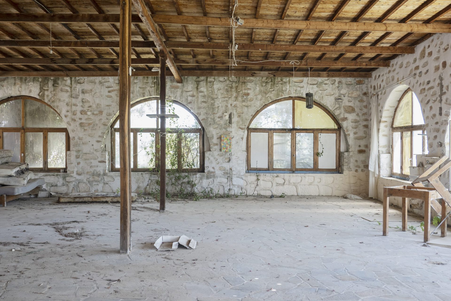 Ishai Shapira Kalter, "Third Stop: Golden Beach", 2021. Installation view. Further down the road to Golden Beach - a long, touristic and golden stretch of sand - near a small vineyard in a spacious abandoned house made of stone and wooden beams, is the location of the third work attached as a relief to a wall.