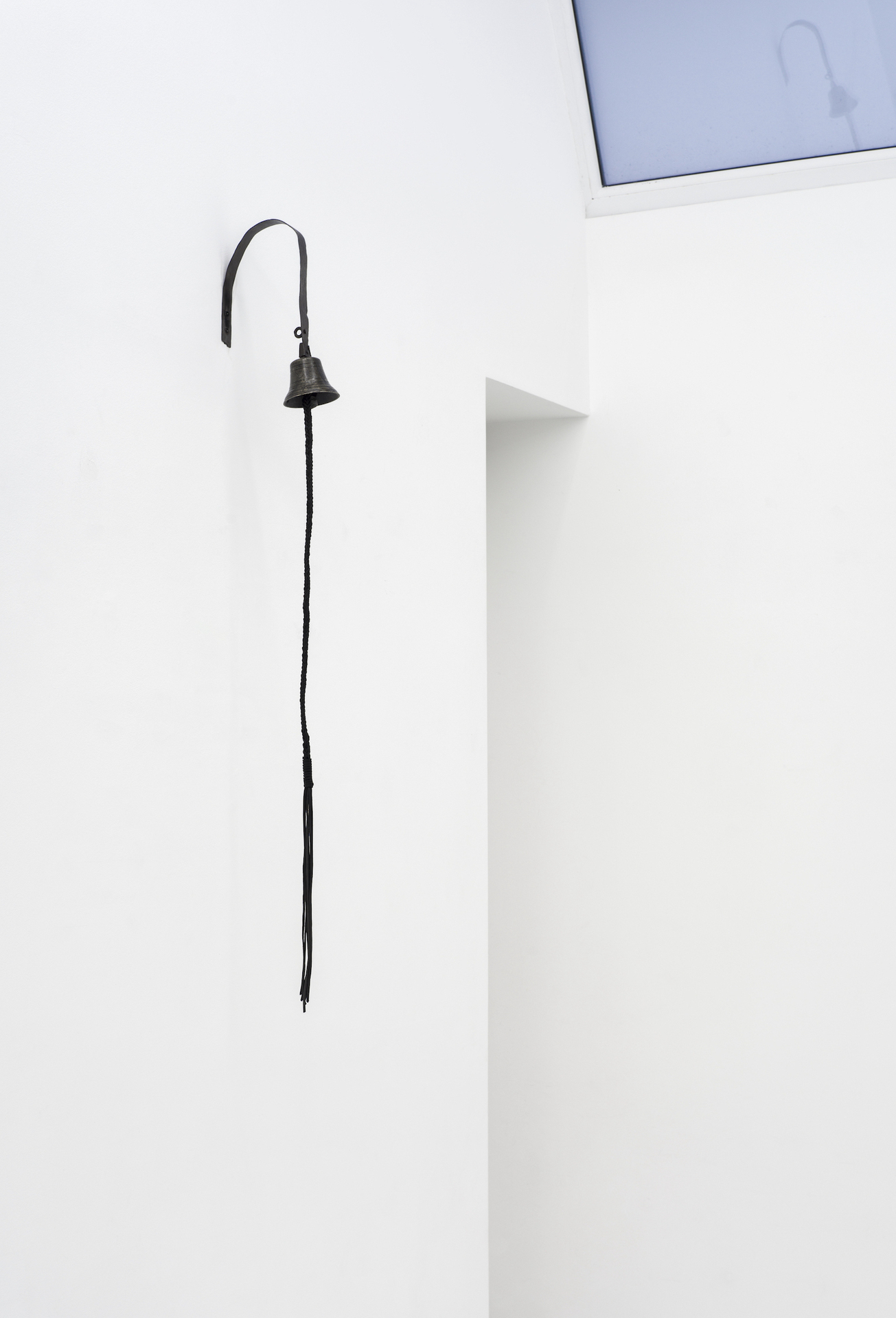 Eliza Ballesteros, Domestic Heck V (strap), antique brass bell, iron, leather laces, 140 x 12 cm, 2021