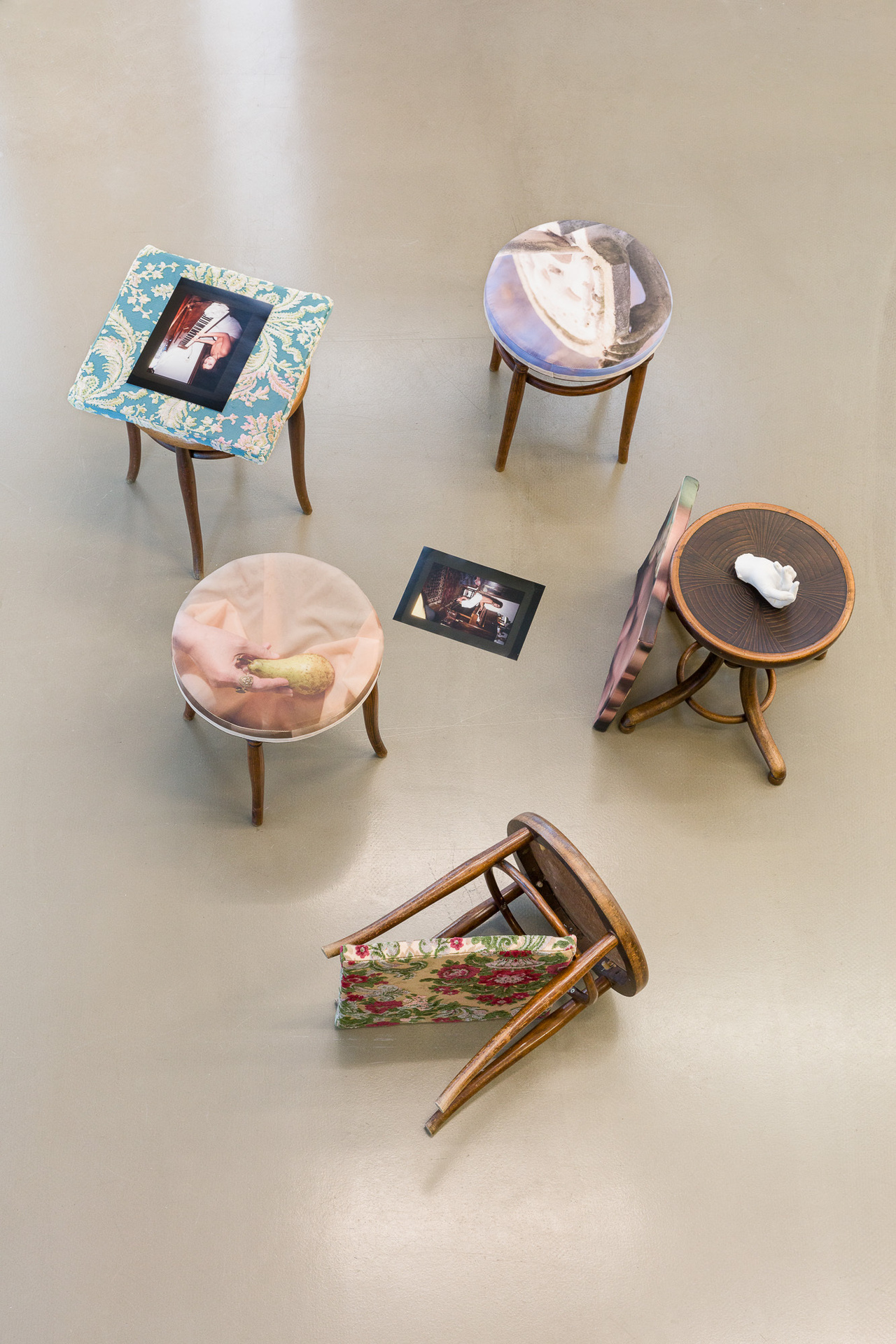 Anaïs Horn: Portraits of a Paralyzed Hand, 2021. Installation with 5 antique Thonet piano stools, upholstering with photo prints on furniture velours, 3 cushions, photo prints on cotton satin and vintage fabrics, 50 × 50 cm each; childhood portraits, 2 Lamb- da c-prints, 29.7 × 21 cm each; My Right Hand, 2021, plaster cast, ca. 20 × 15 cm.