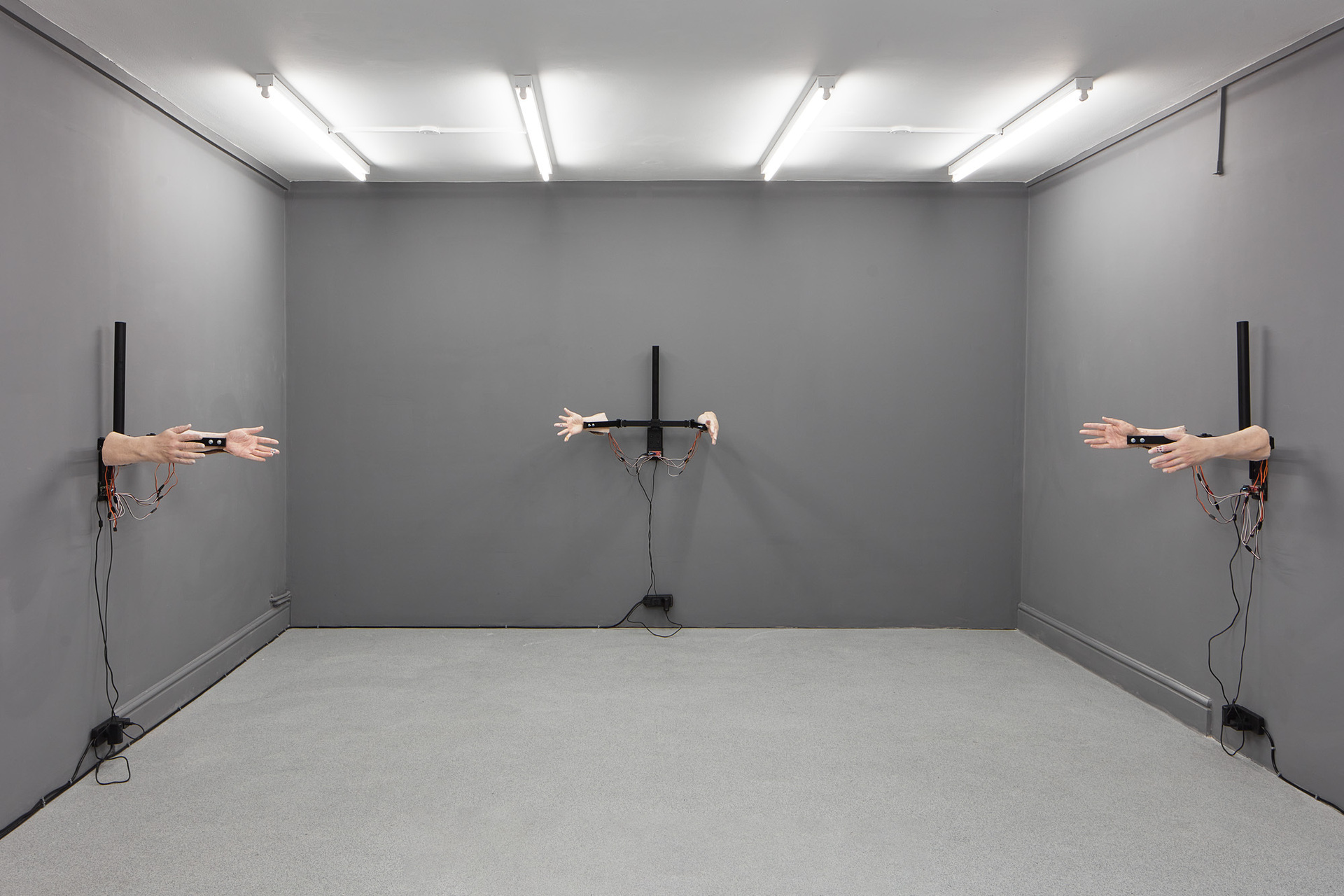 Alex Frost, Passive Aggression 1-3, 2021, Cast silicon hands, servos, pvc tubing, braided fishing line, wood, Raspberry Pi zero WH, SparkFun Servo pHAT, Adafruit Pio LED & 1A & 3A power supplies, plasters, first aid tape & modified dual monitor stand.