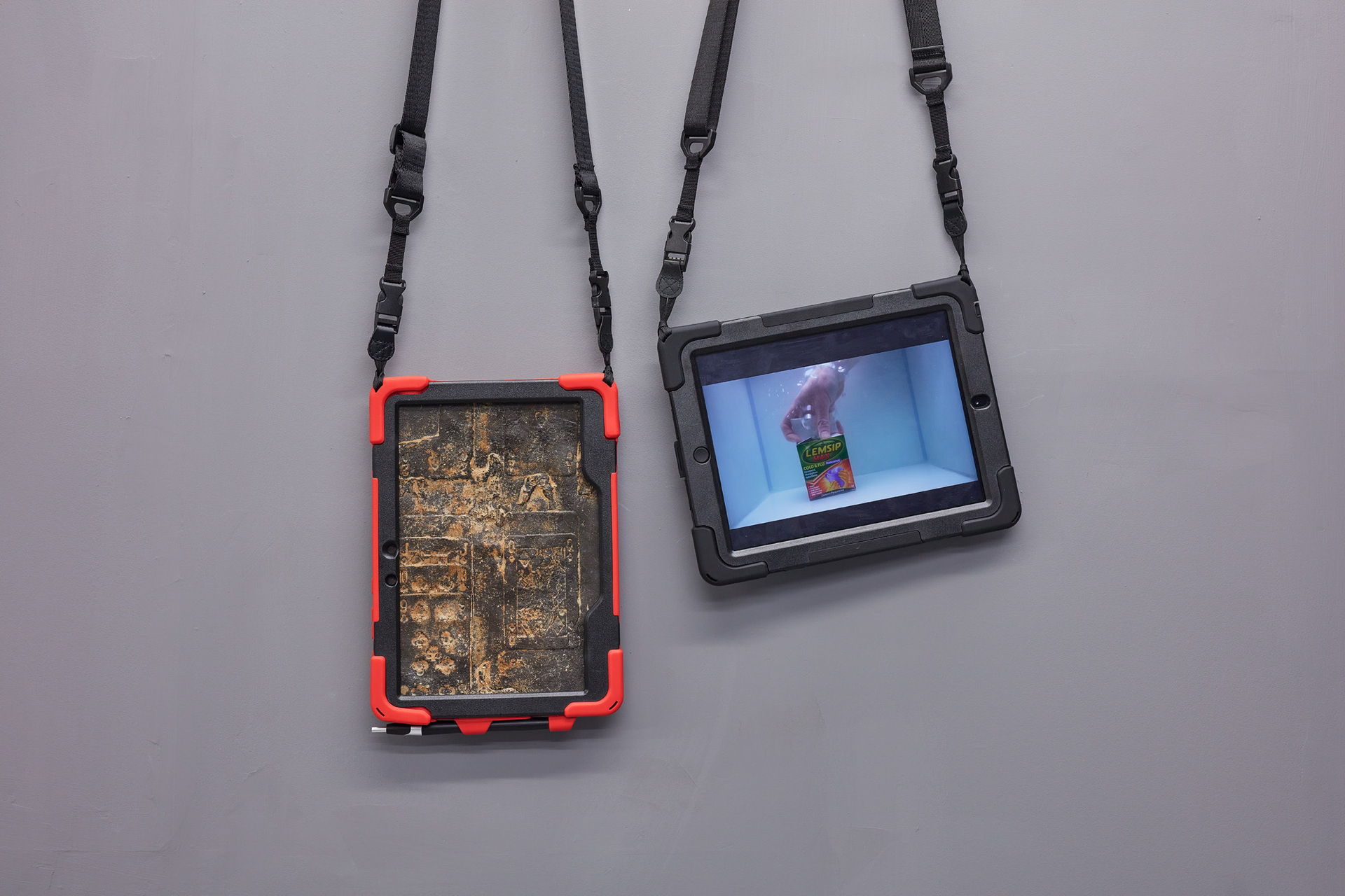 Alex Frost, Passive Aggression 5, 2021, Ipad covers and lanyards, resin cold cast tablet with iron filings (artificially rusted); Ipad with Wet Unboxing videos, 2017-2021