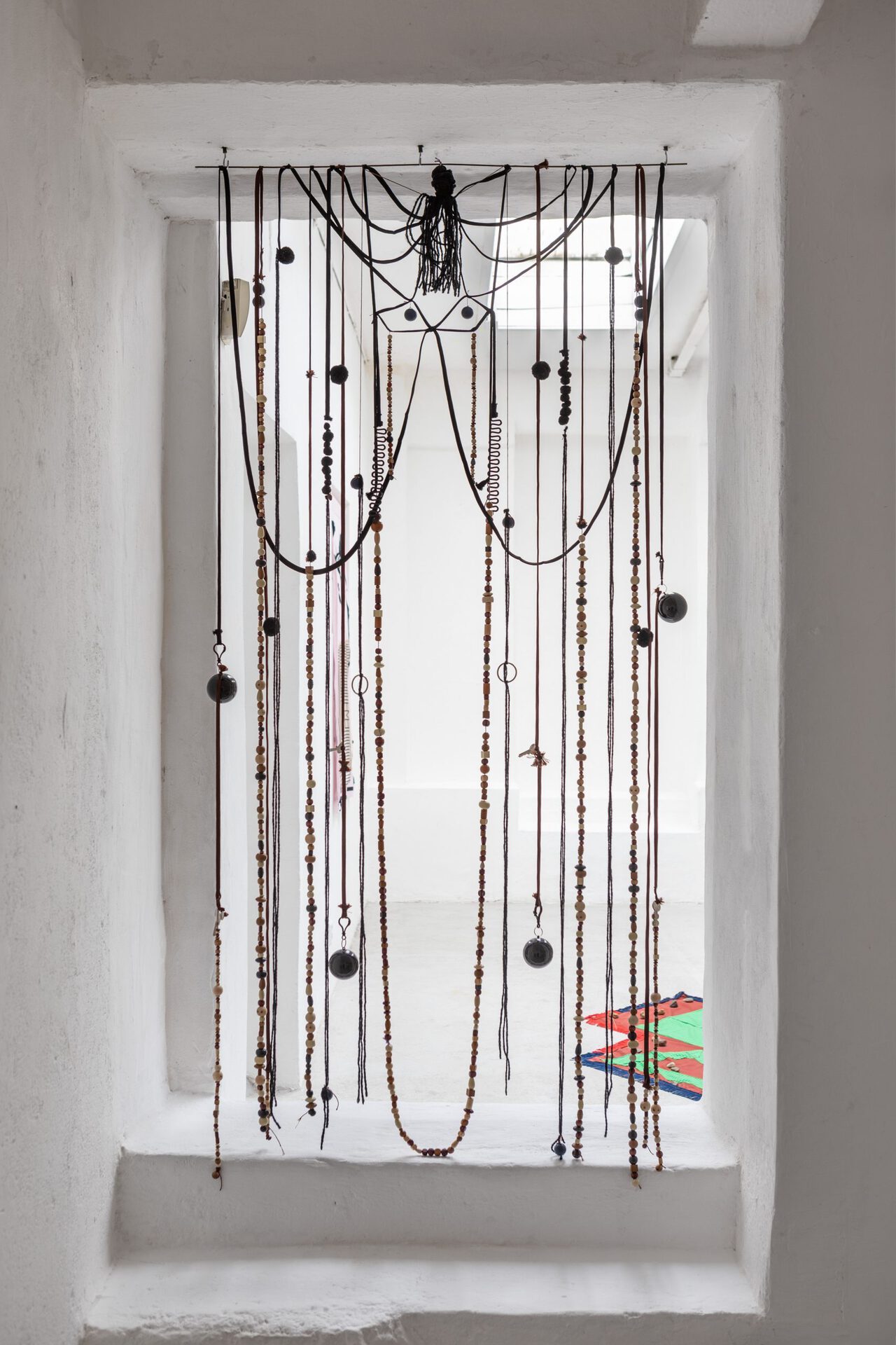 Dropped my Jaw, 2021, metal, wool, beads, shoelaces, plastic balls, plastic, pompoms 205 x 95 cm