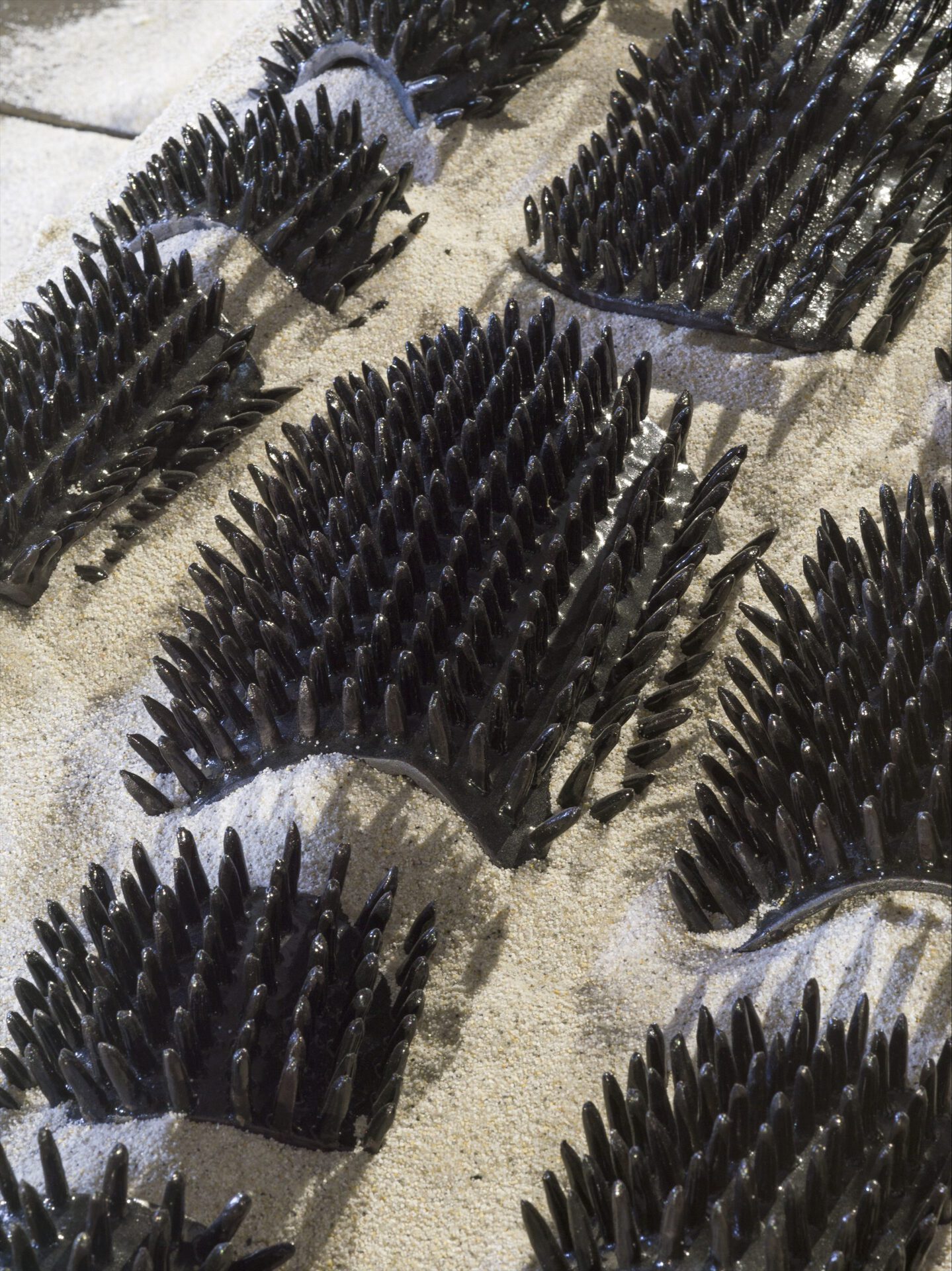 Keegan Luttrell, Barrier (detail), 2021, dims variable, sand, glazed ceramics, stainless steel, wood.