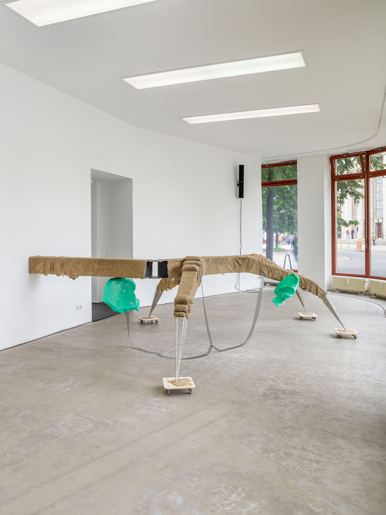 Mara Wohnhaas,“Rekommandeur I”, 2021 2-parts, Ride fragment: Steel, chequer plate, 3 lacquered plastic seats, glass, chain ring belts, 4 dollys, sand, glue, 121 x 443 x 418 cm, Courtesy BQ, Berlin