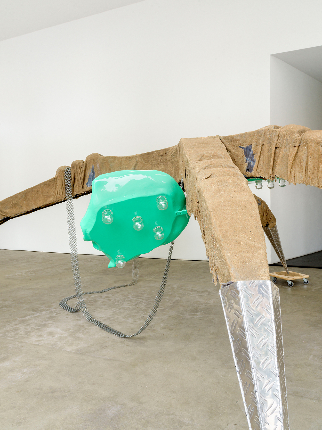Mara Wohnhaas,“Rekommandeur I”, 2021, 2-parts, Ride fragment: Steel, chequer plate, 3 lacquered plastic seats, glass, chain ring belts, 4 dollys, sand, glue, 121 x 443 x 418 cm, Courtesy BQ, Berlin (Detail)