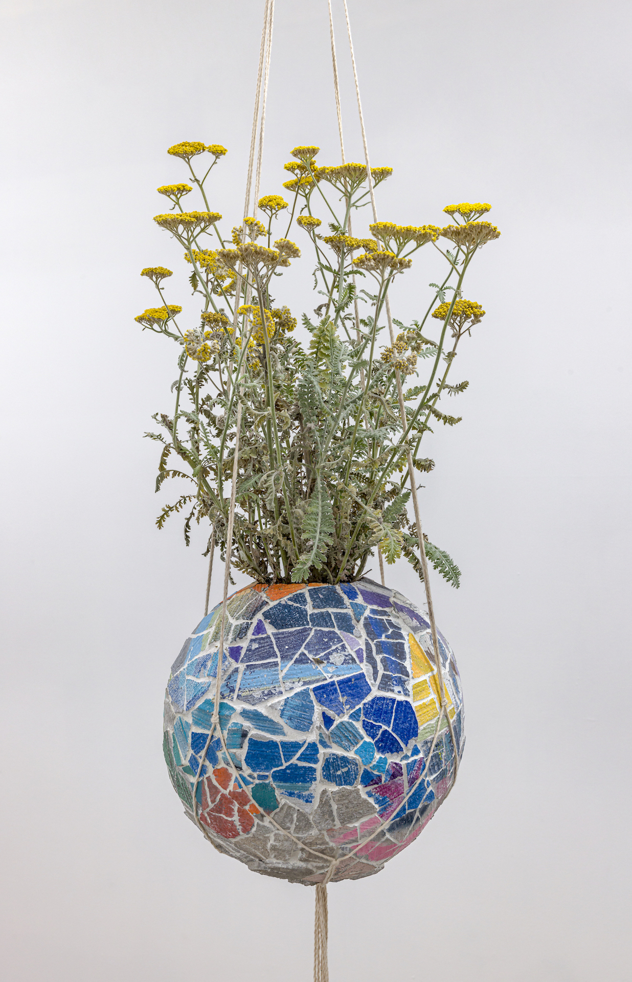 Mark Dudiak; "Regenerative Vessel”; 2021; Found mural fragments (spray paint on concrete), sanded grout, basketball, yarrow plant and cotton cord; 24” x 10” x 10” (planter); 96” x 10” x 10” (total sculpture)