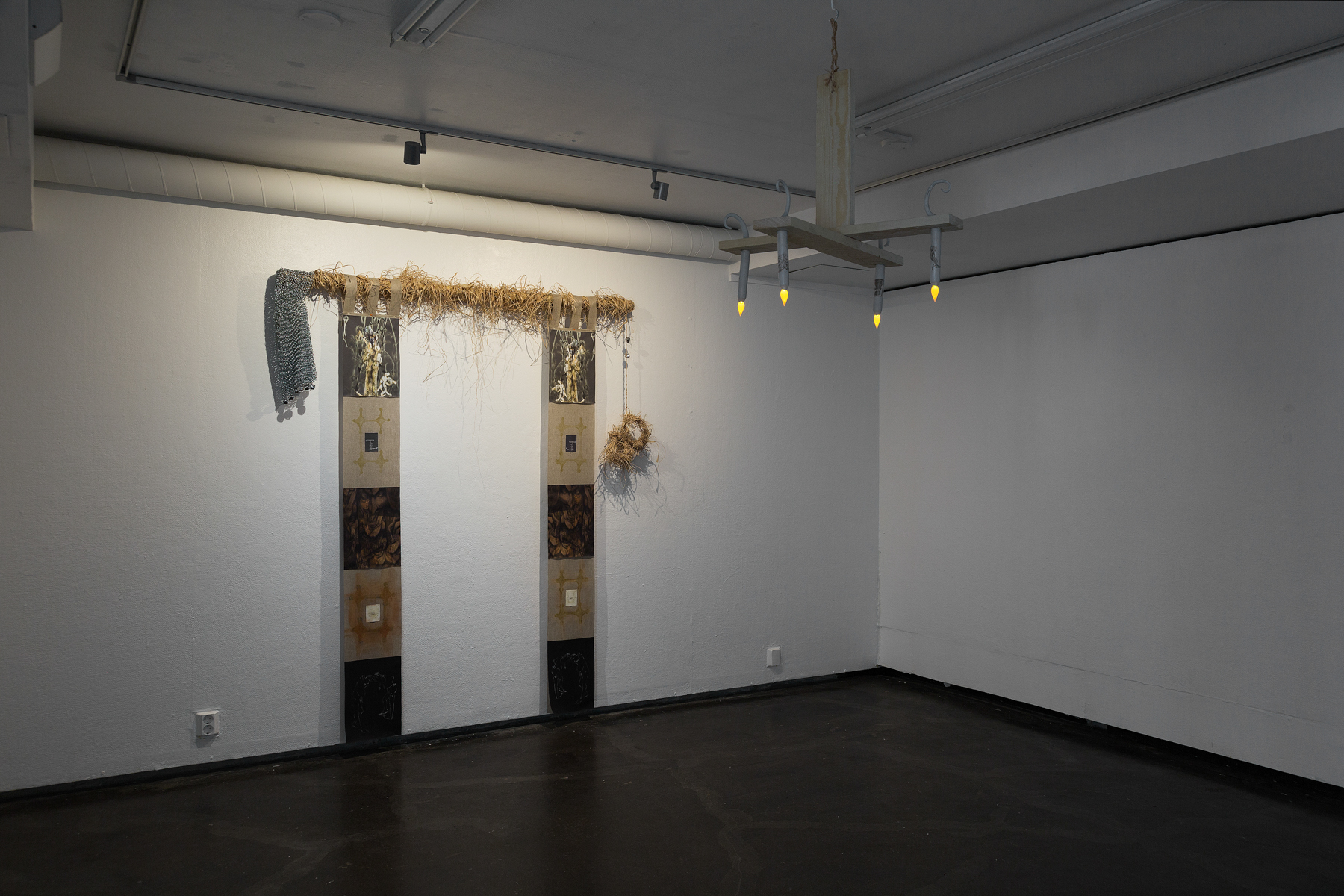 Johanna Härkönen, Ignis Fatuus, 2021, Prints on canvas, linen, watercolour, soft pastel, cotton thread, natural raffia, wooden bar, spray paint, chainmaille, jingle bells Johanna Härkönen, The Riddle, 2021, Wood, LED-candles, colored pencil, modelling compound, natural raffia