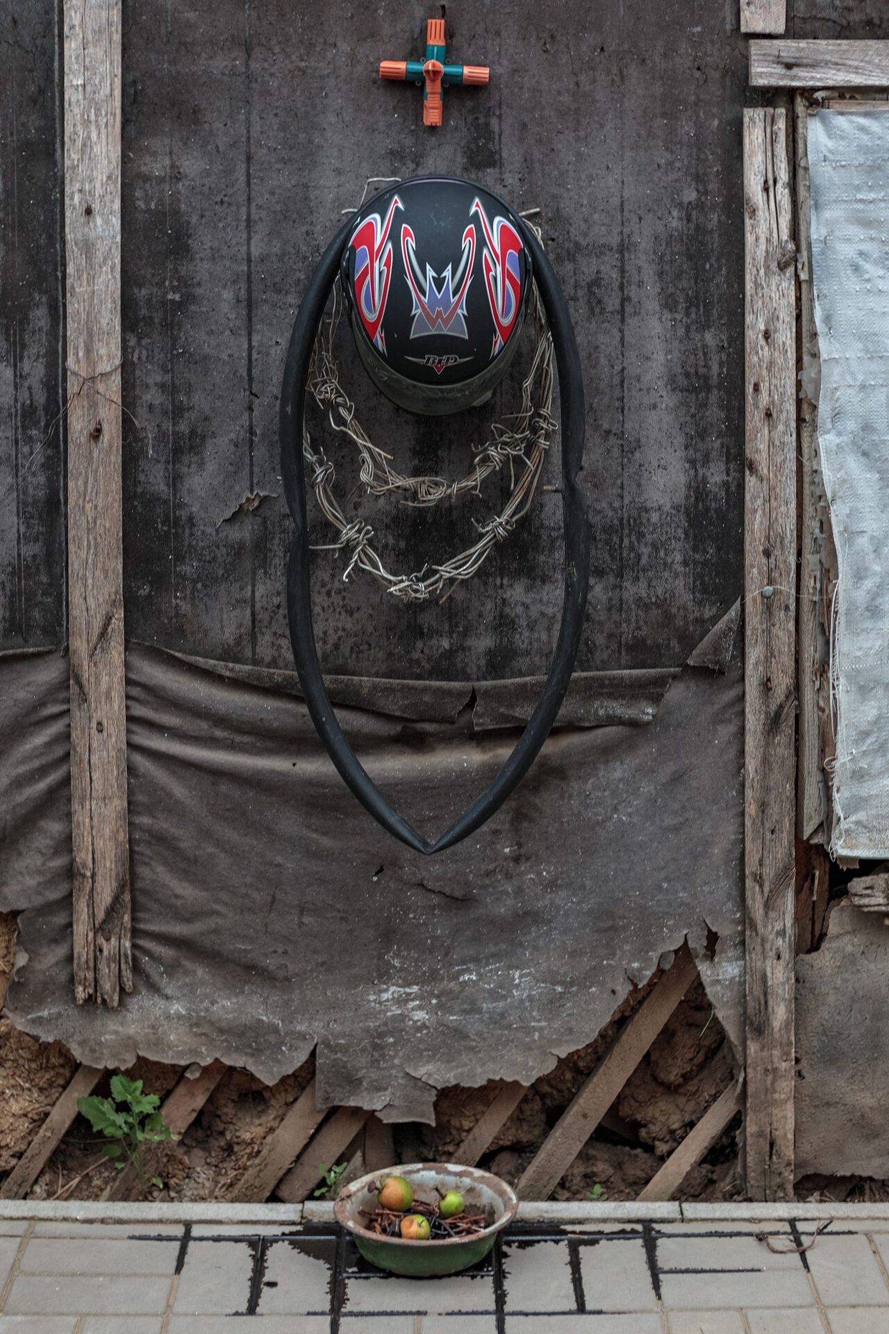 Ritual Object No. 5, 2021, helmet, wire, tire, pot, rusty nails, apples