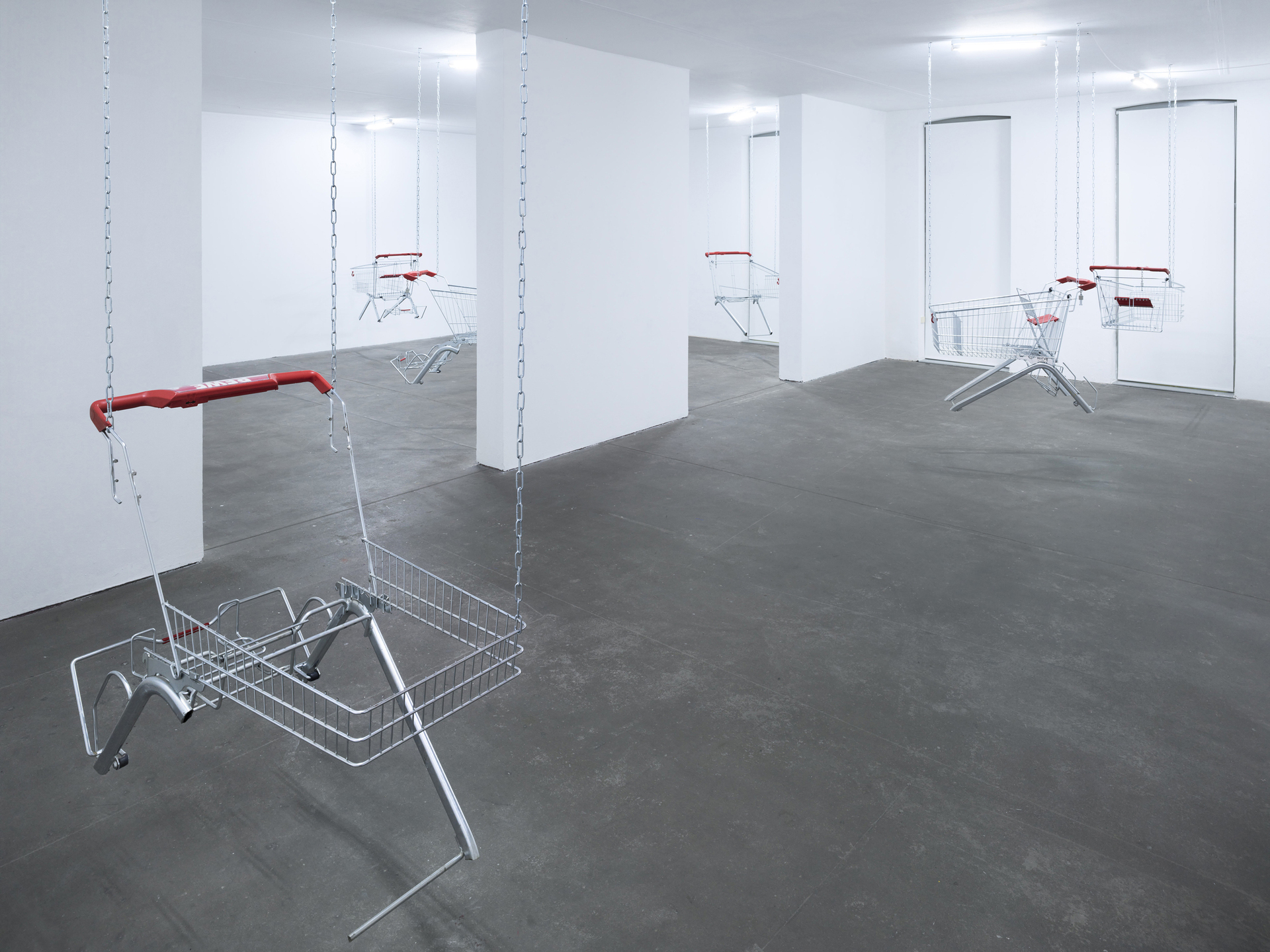 Lars Karl Becker, Tap Water from Coke Bottles, 2021, stainless steel, shopping carts, chains, led fluorescent tube. Photo: Roman Mensing, artdoc.de