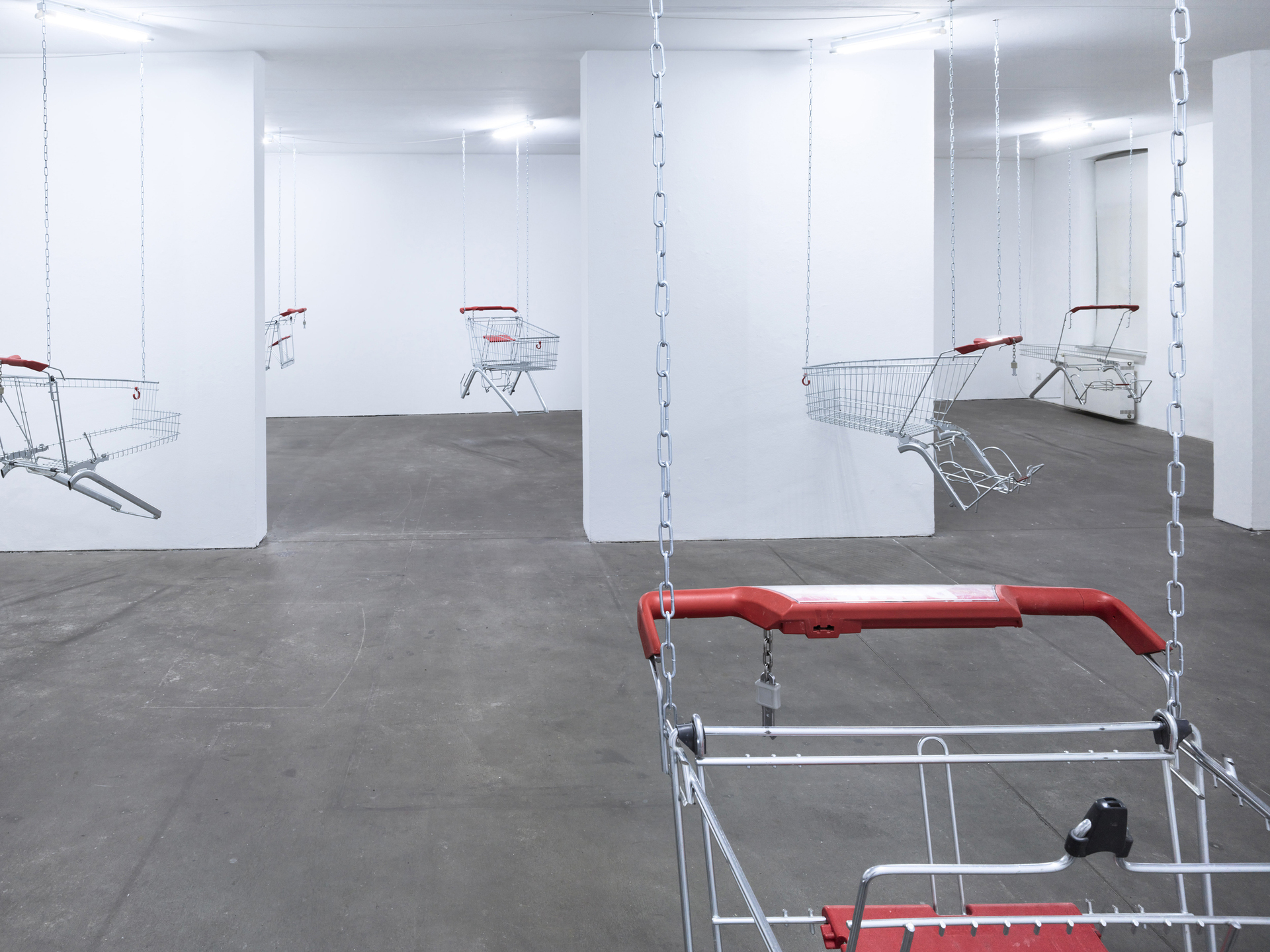 Lars Karl Becker, Tap Water from Coke Bottles, 2021, stainless steel, shopping carts, chains, led fluorescent tube. Photo: Roman Mensing, artdoc.de