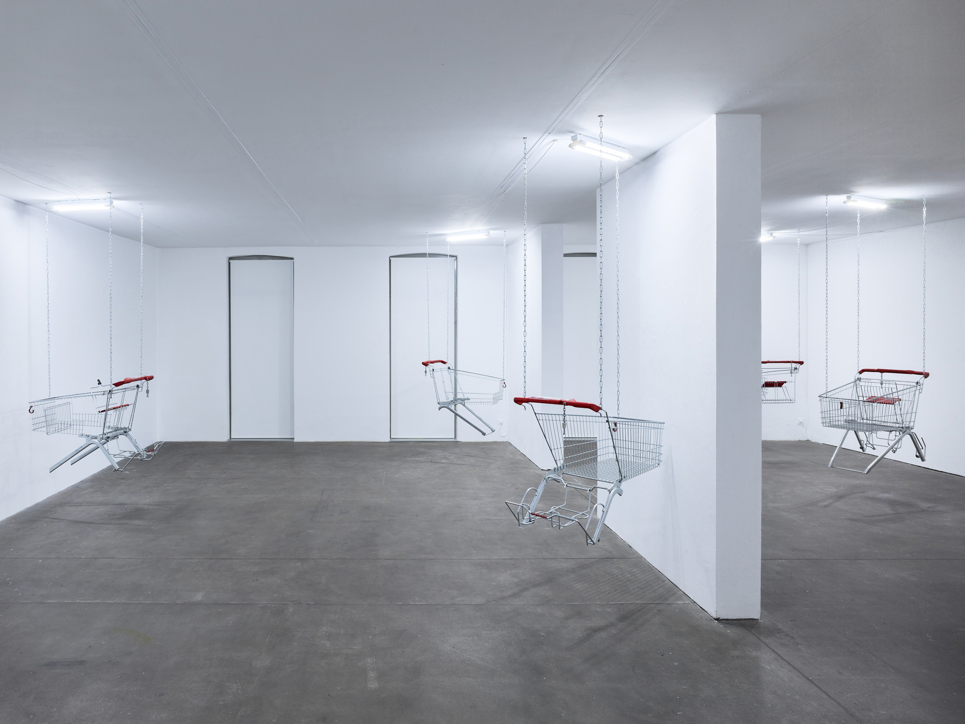 Lars Karl Becker, Tap Water from Coke Bottles, 2021, stainless steel, shopping carts, chains, led fluorescent tube. Photo: Roman Mensing, artdoc.de
