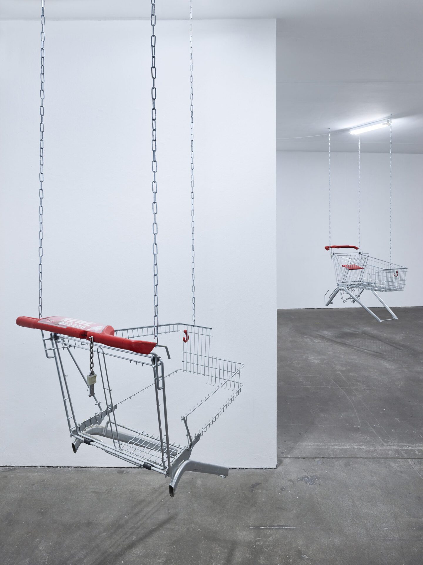Lars Karl Becker, Tap Water from Coke Bottles, 2021, stainless steel, shopping carts, chains, led fluorescent tube. Photo: Roman Mensing, artdoc.de