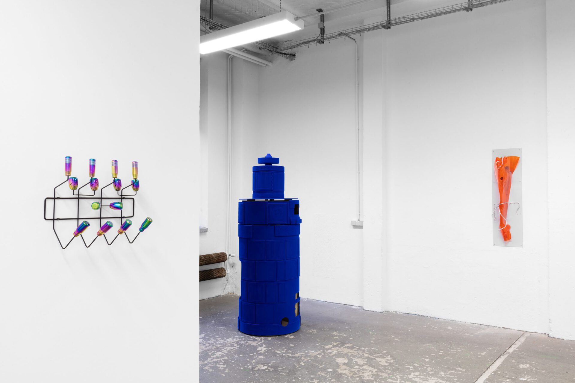 Left: Lena Marie Emrich ride with me (hang it all), 2021 neochrome polished metal, aluminum alloy, steel 43 x 47 x 17 Edition: 6, Middle: Hannah Sophie Dunkelberg, SUN CITY (west), 2021 MDF, Sperrholz, synthetische Faser 210 x 75 x 75 cm, Right: Hannah Sophie Dunkelberg, THE BIG EXCUSE (Cornflower), 2021 Metall pulverbeschichtet, Acrylglas, Kornblume 115 x 33 x 40 cm