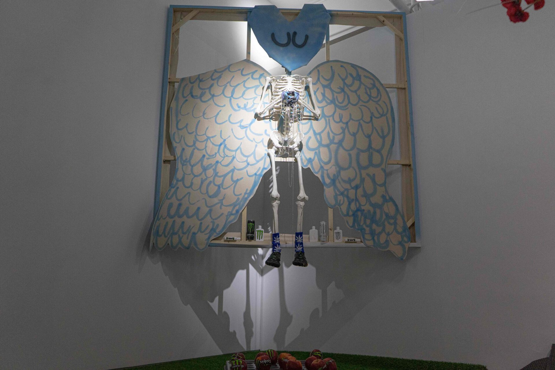 Chen Pin Tao, Angel 001, digital print on canvas, PVC skeleton model, spray paint, steel chains, monster energy, holy water bottle, 3M gloves, taxidermized bird, sporting shoes, weed socks, 220 x 200 x 40 cm