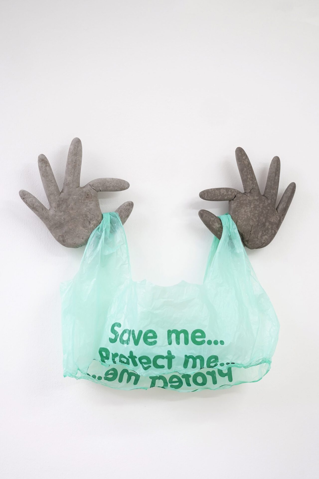 Ilona Balaga, Caring, 2021, cement cast and plastic bag, 45/40/5 cm