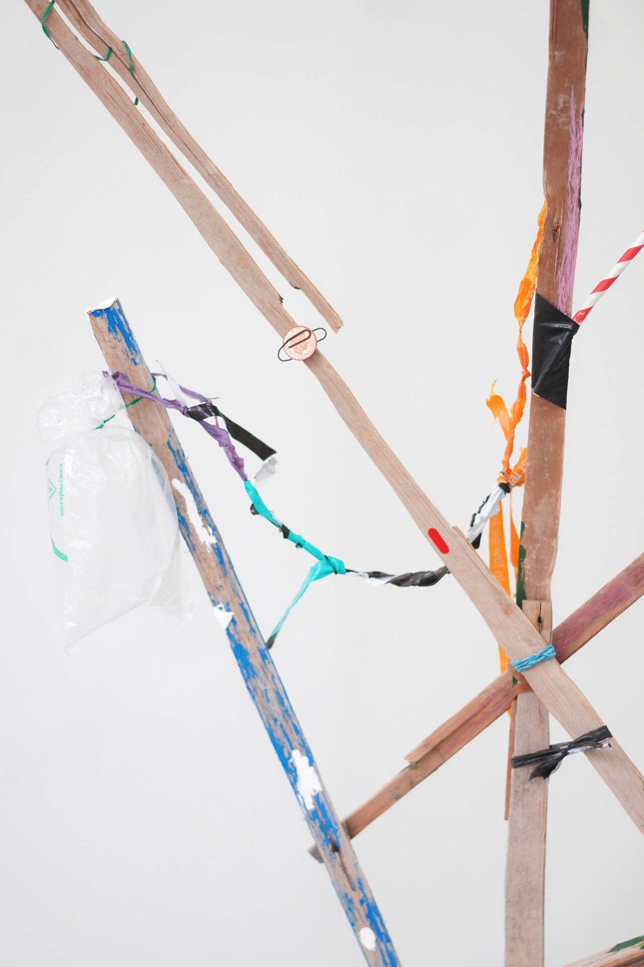 Ilona Balaga, Passerby (detail), 2021, found wood, concrete, acrylic paint, plastic bags, 1p, tree branch, acorn, metal hanger, pull-tab, snail, string, rubber bands, gaffer tape, newspaper, straw, metal wire, sewing thread, peach kernel, paperclip, 195/70/27 cm