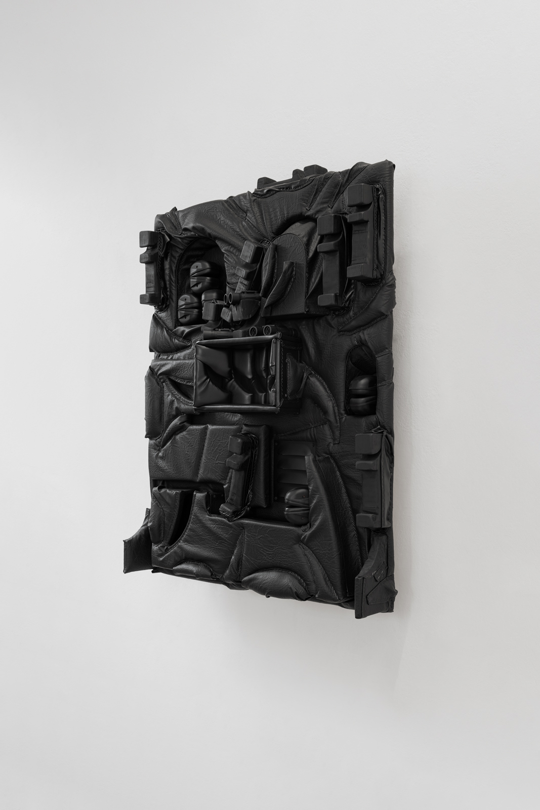 Cezary Poniatowski  Untitled, 2022 Pleather, plywood, upholstery foam, anti-noise earmuffs, staples, binoculars, 125x100x20 cm Courtesy: The Artist Side View