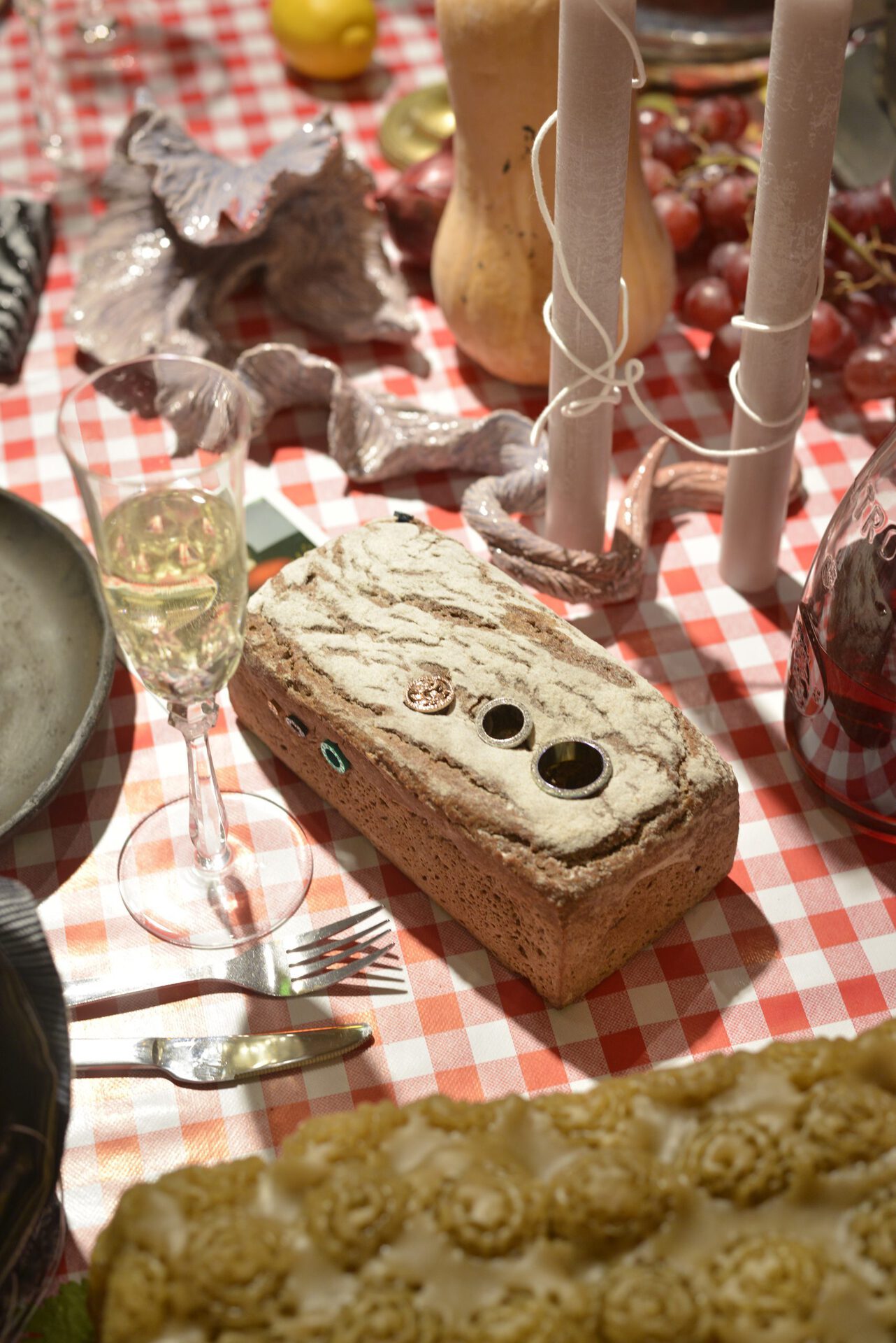 Installation Shot, bread:Johannes Büttner Dinkelbiobrot , 2022 Dinkelbiobrot, flesh tunnels, candles:Ziva Drvaric Untitled , 2022 paraffin, Baumwolle dimensions variable, ceramics:Anka Helfert Some of the fruits of the rather long conversation about infinite growth, 2022 glasierte Keramik 13 x 18 x 40 cm