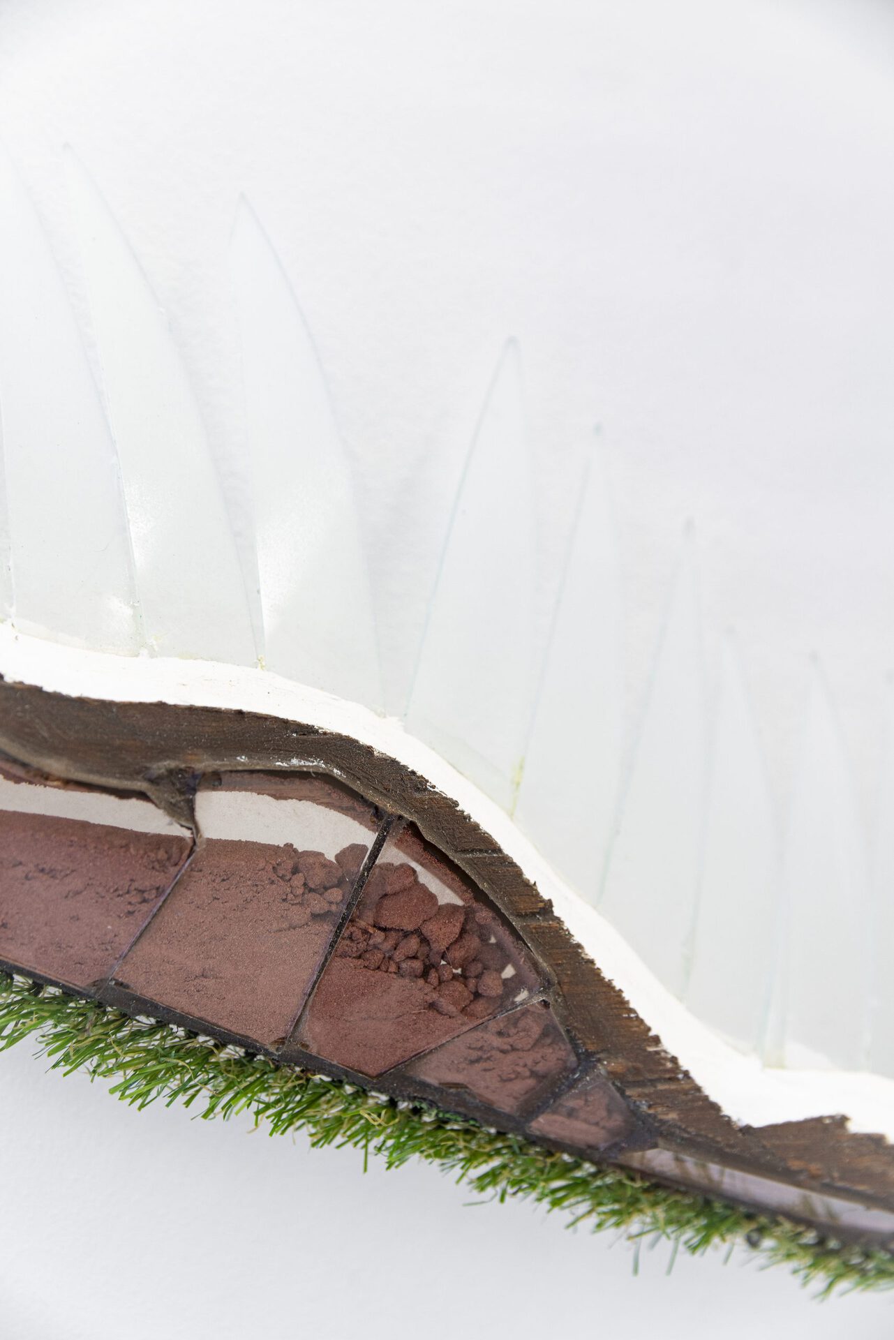 Josephine Baker - Outfaller #2, 2021 (detail 1), artificial grass, cliff sand (Jurassic Coast), glass, hedge shears, plywood, plaster, silicone, varnish, wire and fixings, 101x71x9 cm