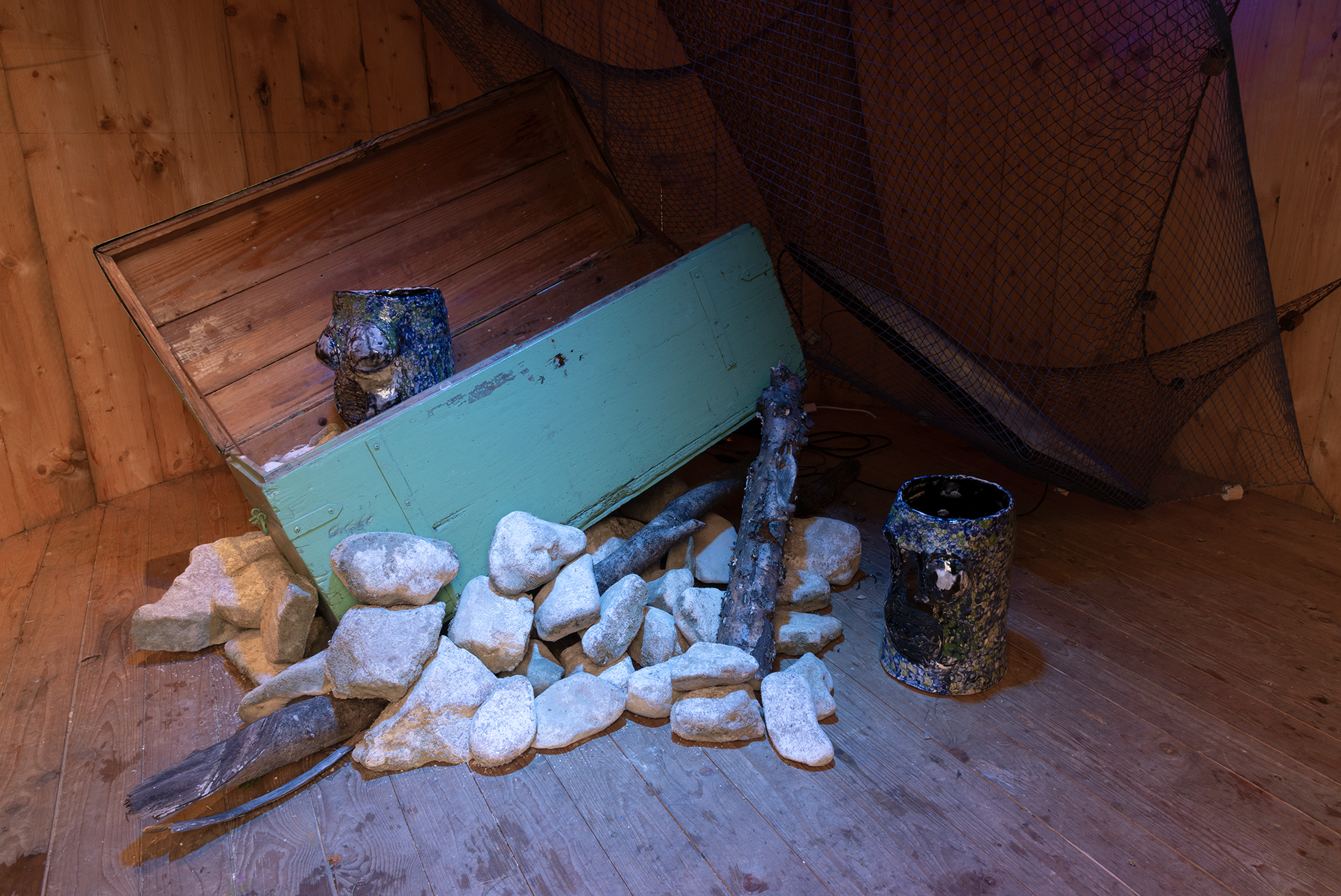 Maya Quilolo. Who carries the Atlantic’s secrets has learned to breathe inside water, 2021. Drawings, plexiglass (words), fishing nets, video, chest, ceramic.