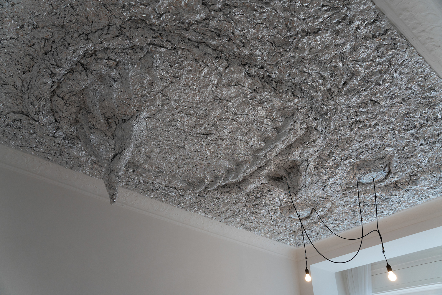 Tobi Keck, Lurer, 2022, Aluminium foil, stucco rosettes, light bulbs, building’s electricity infrastructure, 3.2m x 5.2m x 0.8m, View 3