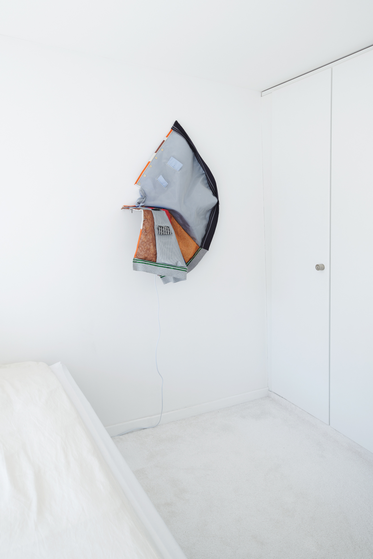 Hansol Kim, poncho to shelf ,2021, domestic textile, mesh, button, shower corner shelf, stretchy rib, yarn, plastic piping, bias, bolt and nut 72.3 x 26 x 84 cm