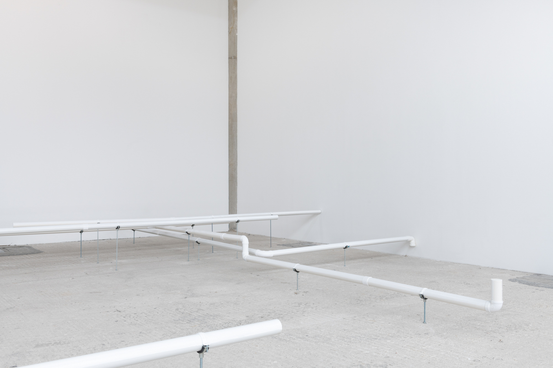 Rosario Aninat, Pipes #2, 2022, white pvc pipes on varnish, variable dimensions.