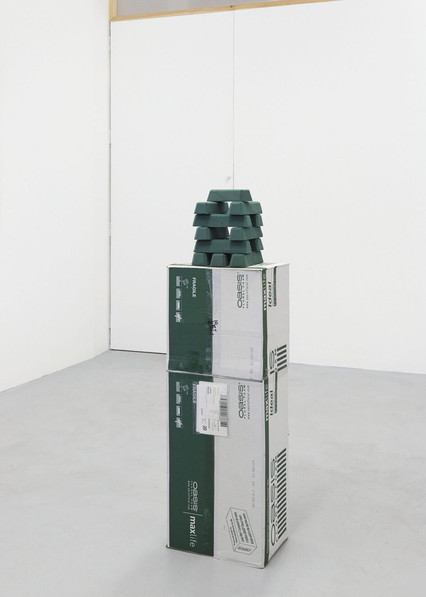 Max Petts, MAX|LIFE, 2022, ardboard, sellotape, phenol-formaldehyde bricks, cinder block, floral wire, looped audio, sticker, 32 x 24 x 116cm approx.