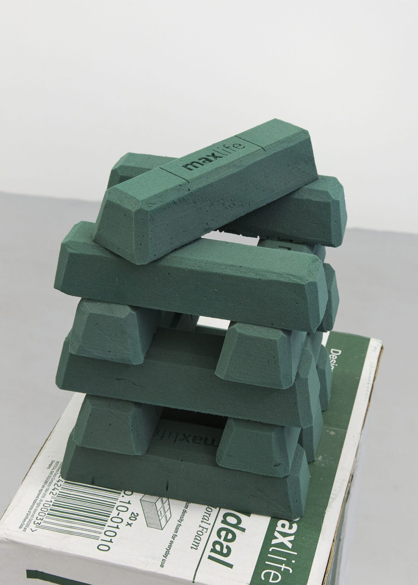 Max Petts, MAX|LIFE, 2022, ardboard, sellotape, phenol-formaldehyde bricks, cinder block, floral wire, looped audio, sticker, 32 x 24 x 116cm approx.