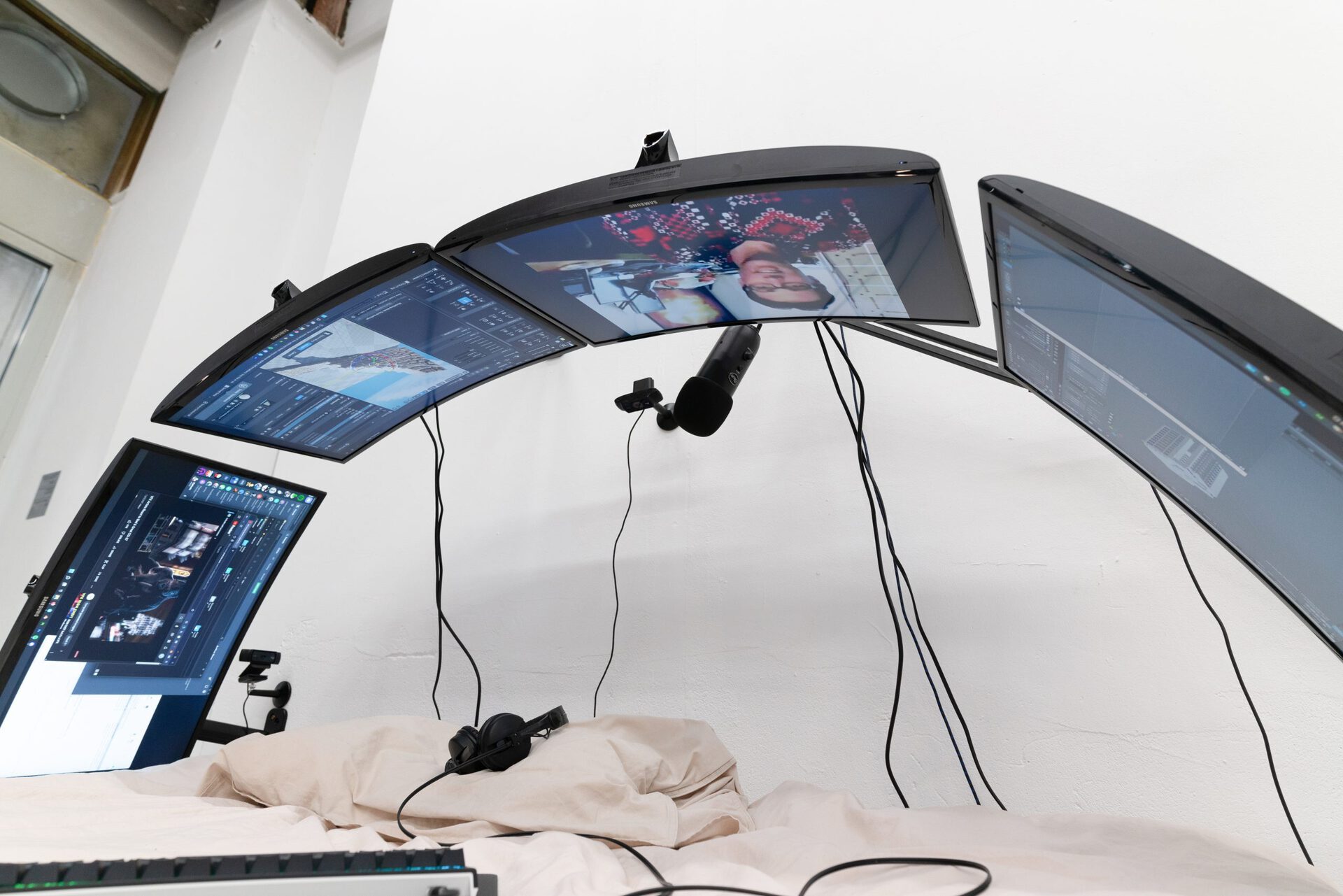 Filip Kostic, Bed PC, 2021, Custom built water cooled computer built into the frame of a bed, bed size variable, 4 curved monitors, cables mounted to wall, keyboard, streaming microphone mounted to wall, webcams, gaming mouse, peripheral computer (detail)