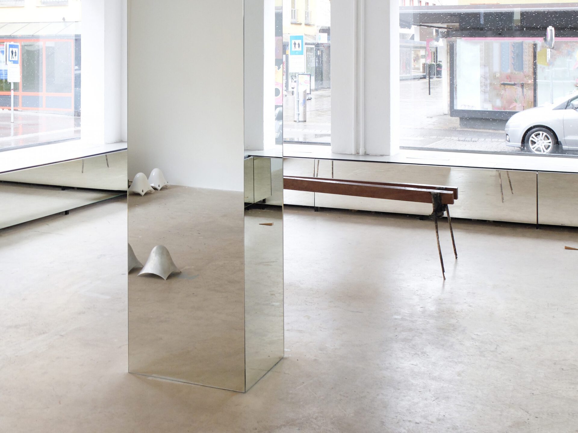 fig18, left to right; Aaron-Amar Bhamra, untitled, 2022, various dimension, two speakers depending on their shell, Aaron-Amar Bhamra, untitled (shell), 2022, (each) 21 x 21 x 21 cm, aluminum, Thomas Supper, ohne Titel (Bank), 2022, 59 x 213 x 55 cm, wood, aluminum, steel