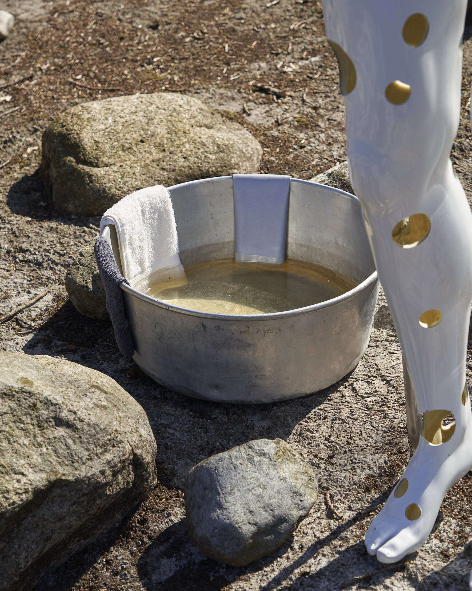 Jan S. Hansen, Untitled, 2022, mannequin, aluminium bowl, washcloths, reflective fabric, resin.