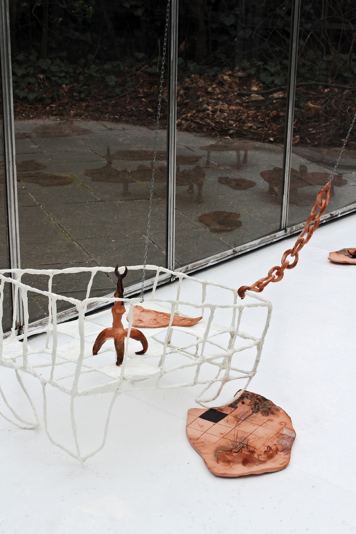 Anna Bochkova, Rocking Cradle with Security Skin and Toy, 2022, papier-mâché, ceramics, steel wire, steel chains, 42x64x48 cm
