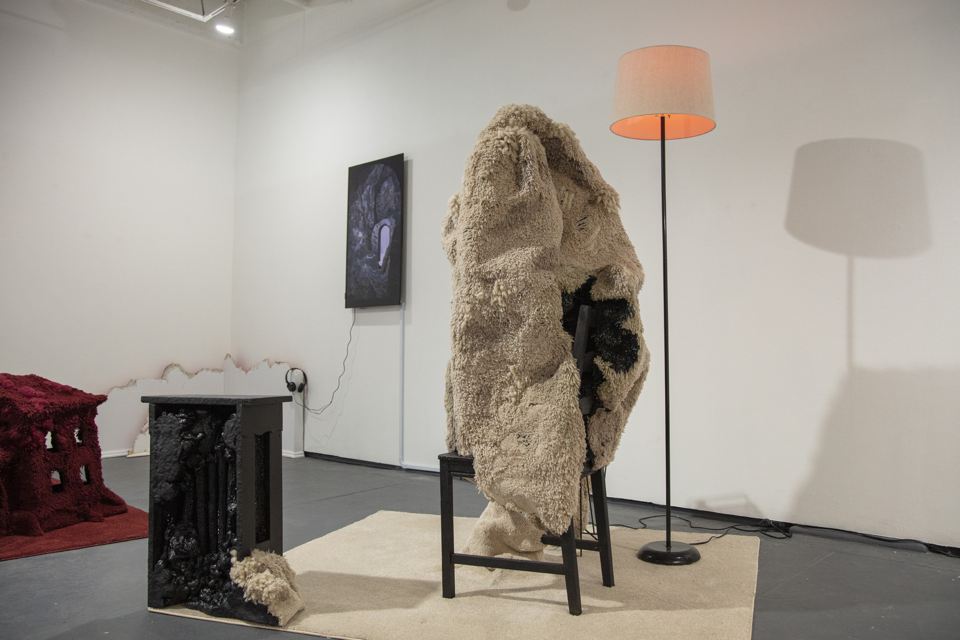 Kate Stone, The Soft Tectonics of Fevered Bodies, 2022, Carpet, found furniture, wool, 40hz bulb, single-channel animation, cell phone, plaster, wax, epoxy clay, polyurethane foam, flex paste, wire, wood, acrylic paint, 5'8" x 4'10" x 5'2"
