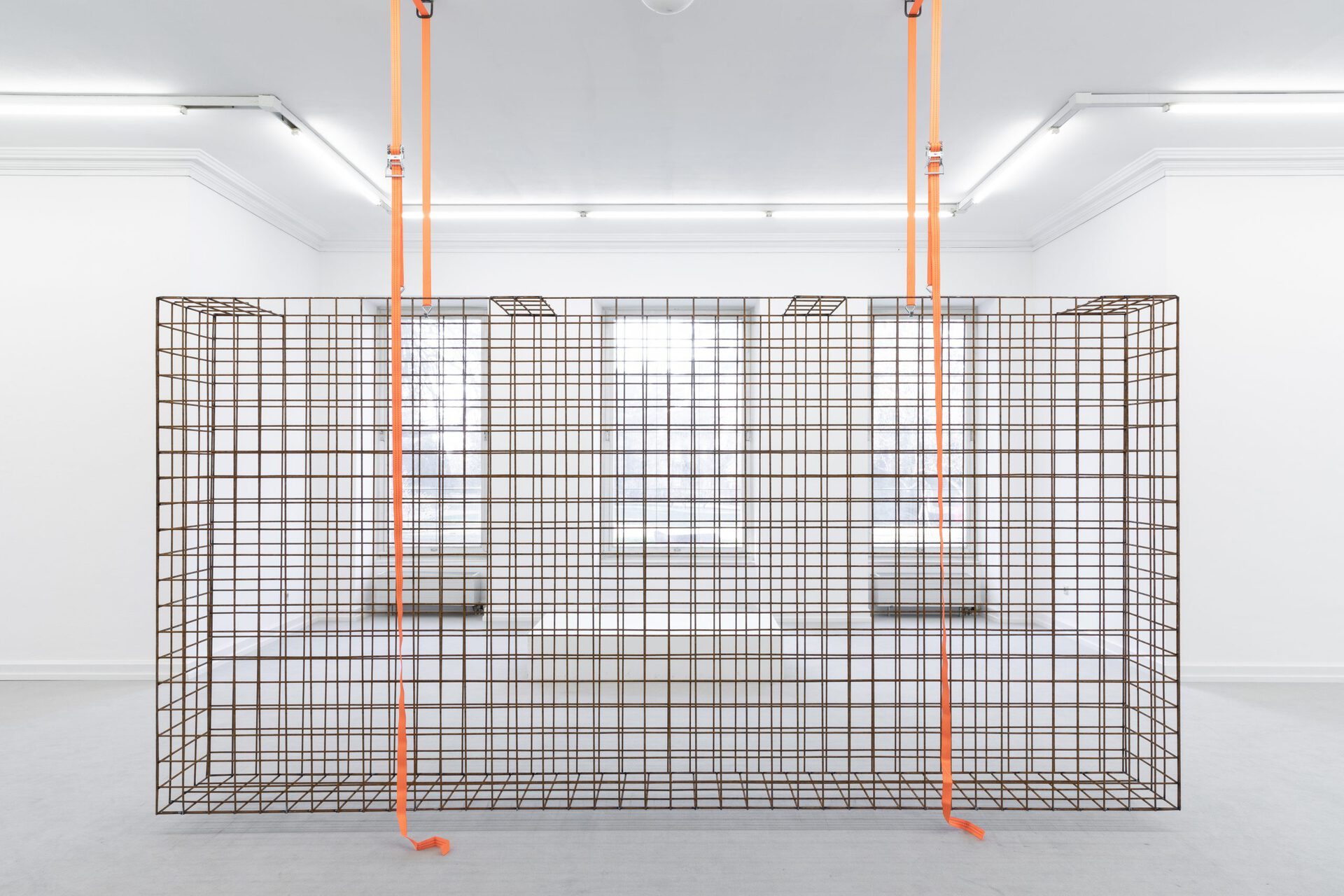 Lukas Weithas, the hanging cage in the white space, 2022, metal, tension belts, 400x200x40cm