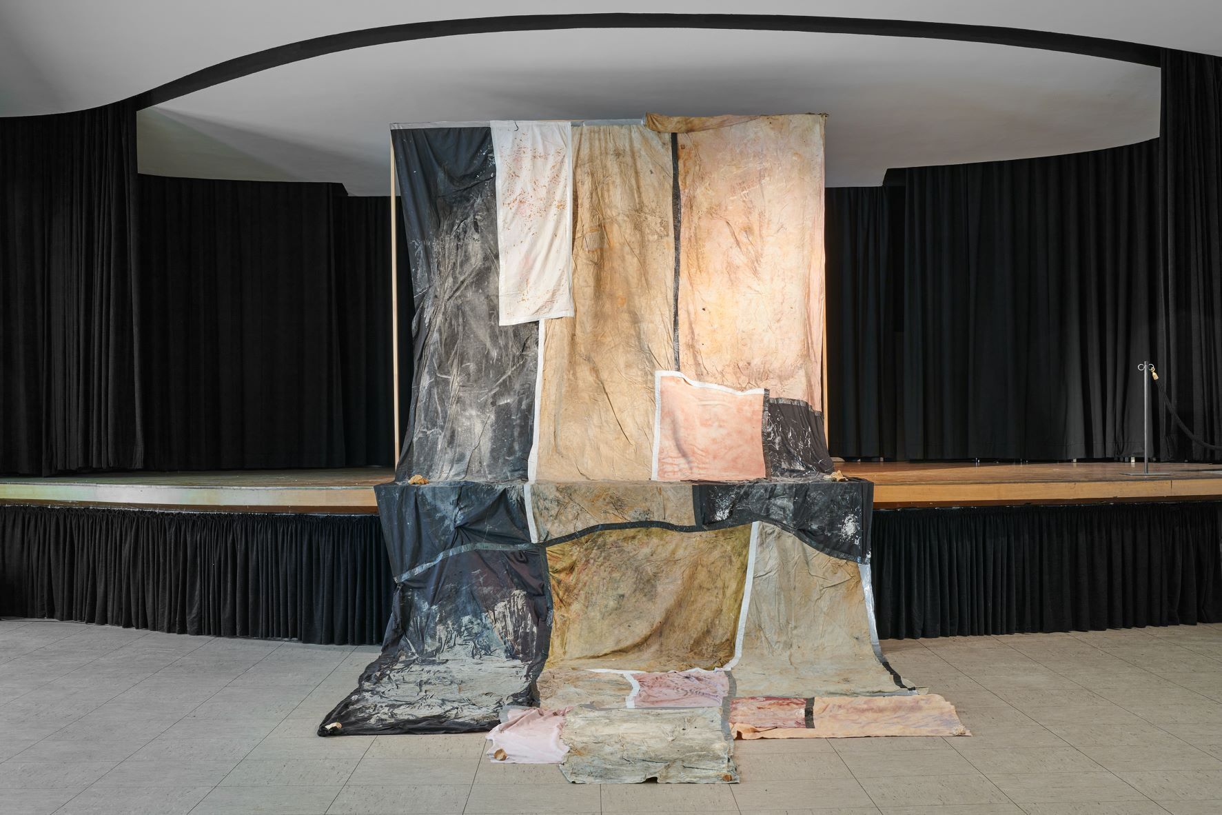 Dala Nasser: Red in Tooth, 2020 – 2021 – 2022. Discarded fabric, buried underground for 2 weeks to 3 months, ash, charcoal, rainwater. Kölnischer Kunstverein, 2022. Courtesy: the artist and Deborah Schamoni. Photo: Mareike Tocha.