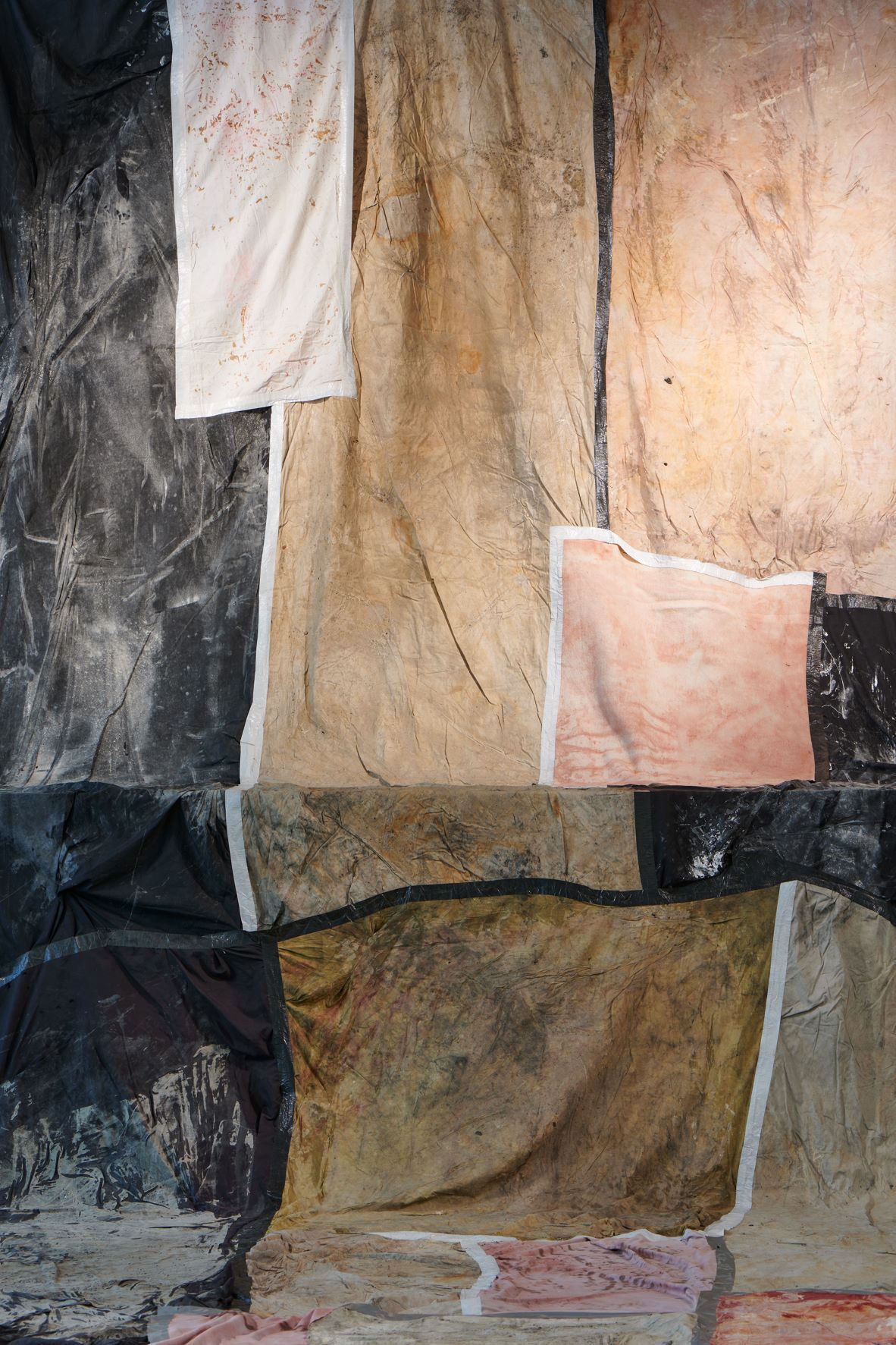 Dala Nasser: Red in Tooth, 2020 – 2021 – 2022 (detail). Discarded fabric, buried underground for 2 weeks to 3 months, ash, charcoal, rainwater. Kölnischer Kunstverein, 2022. Courtesy: the artist and Deborah Schamoni. Photo: Mareike Tocha.
